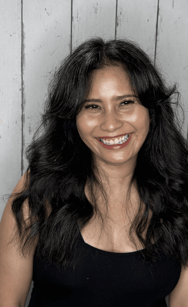 Woman smiling with long black wavy hair in the Inspire Studio Hair Salon