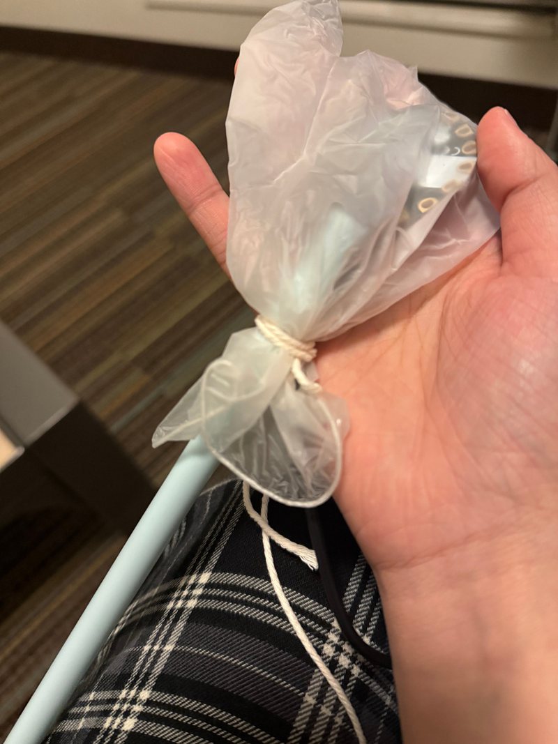 The glove inflated through a straw and tied off with cotton string, the board visible inside