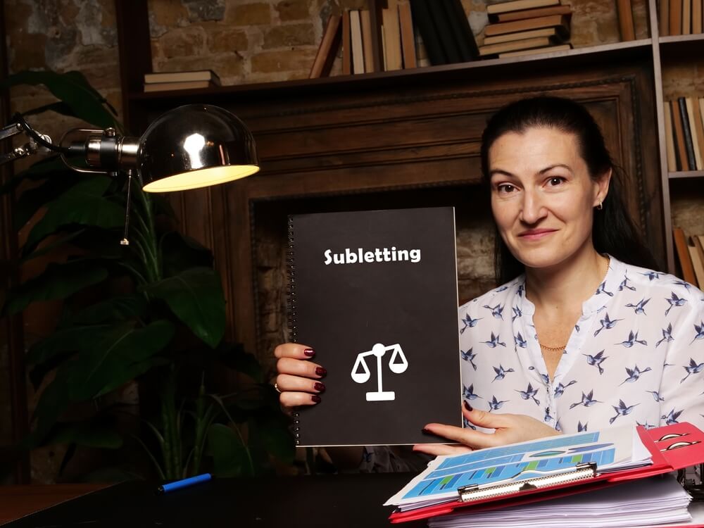 Woman holding sign that reads "subletting"