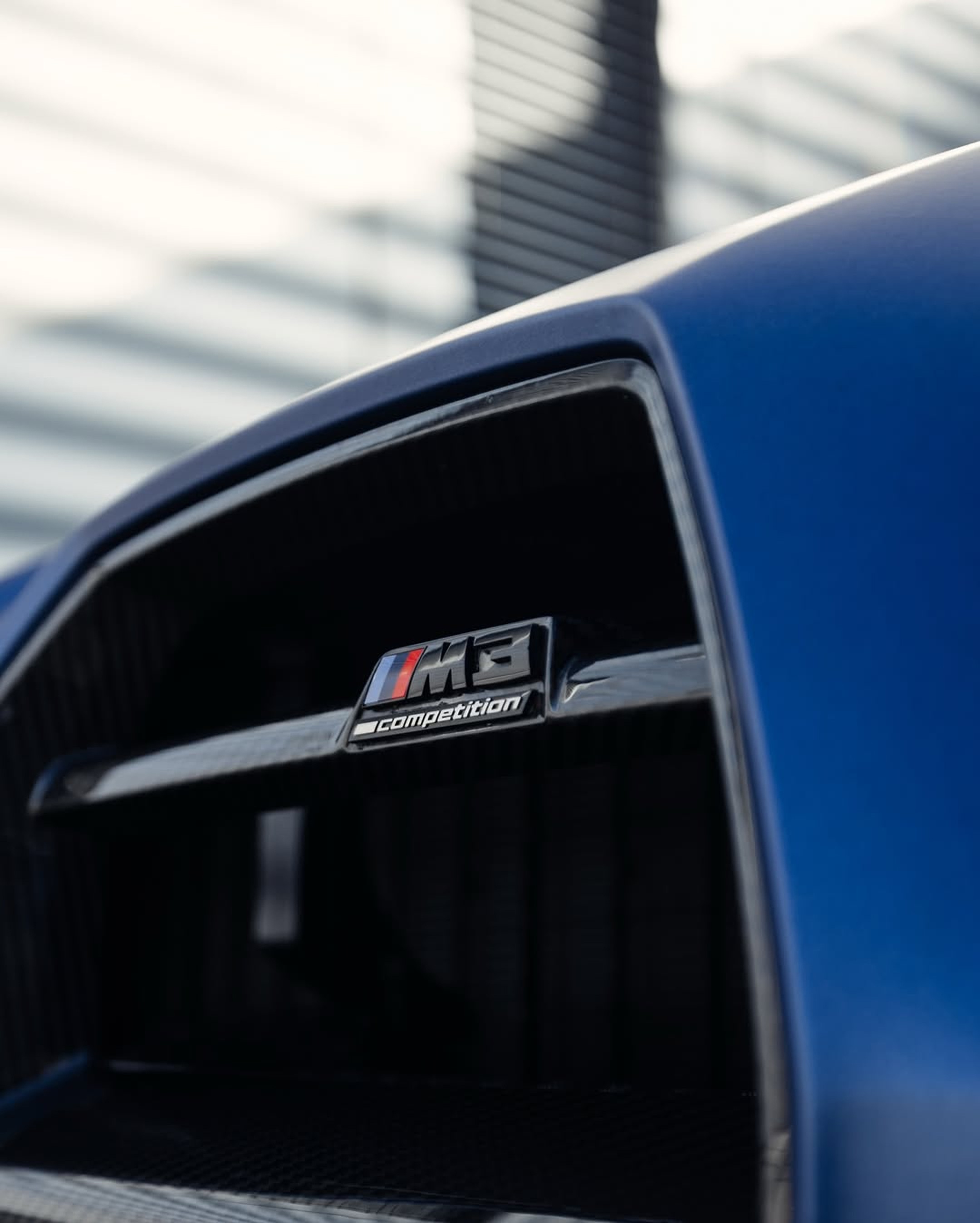 Calandre d’une BMW M3 Competition bleue mate en gros plan