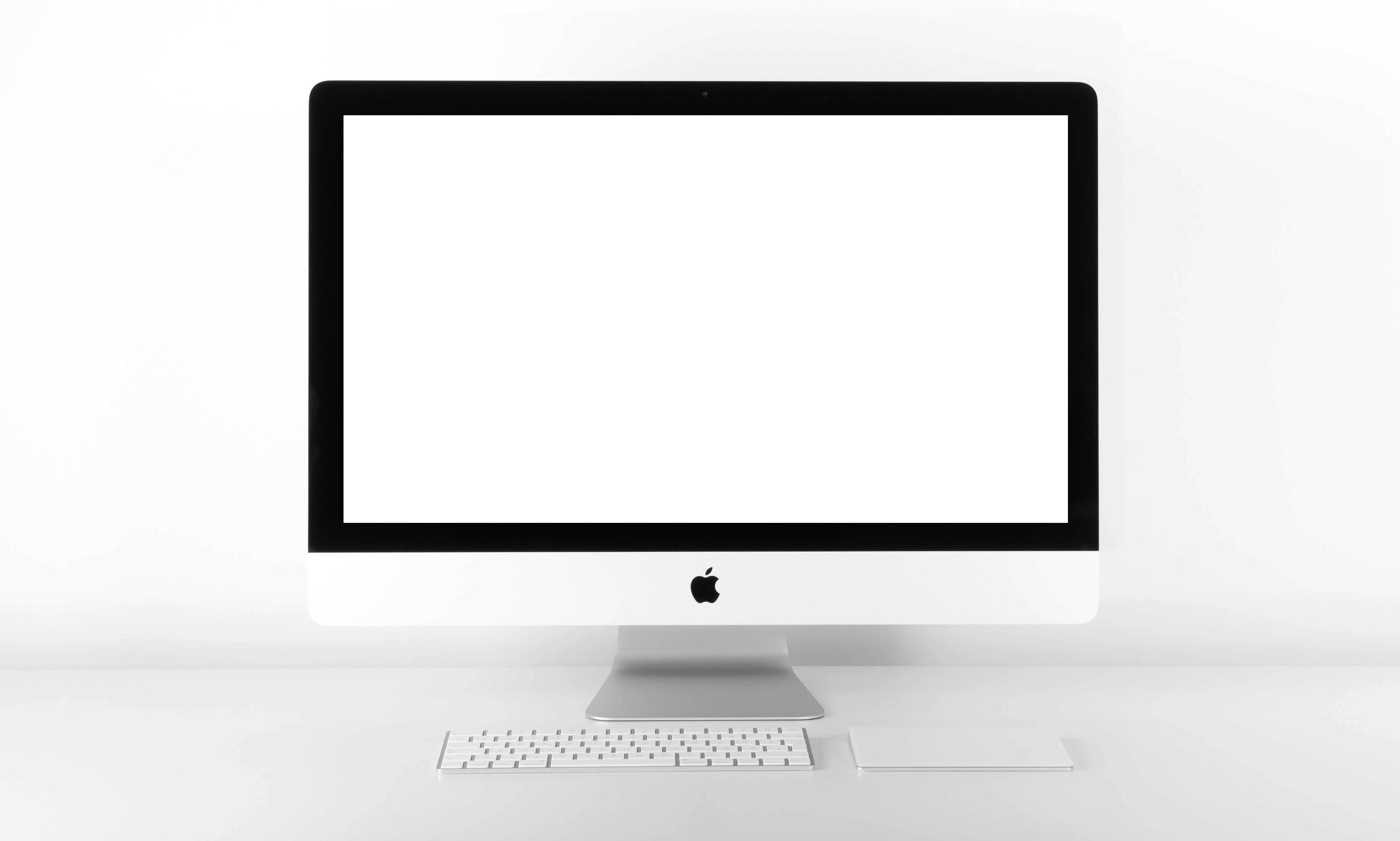 silver iMac with Apple Magic Keyboard on white sufrace