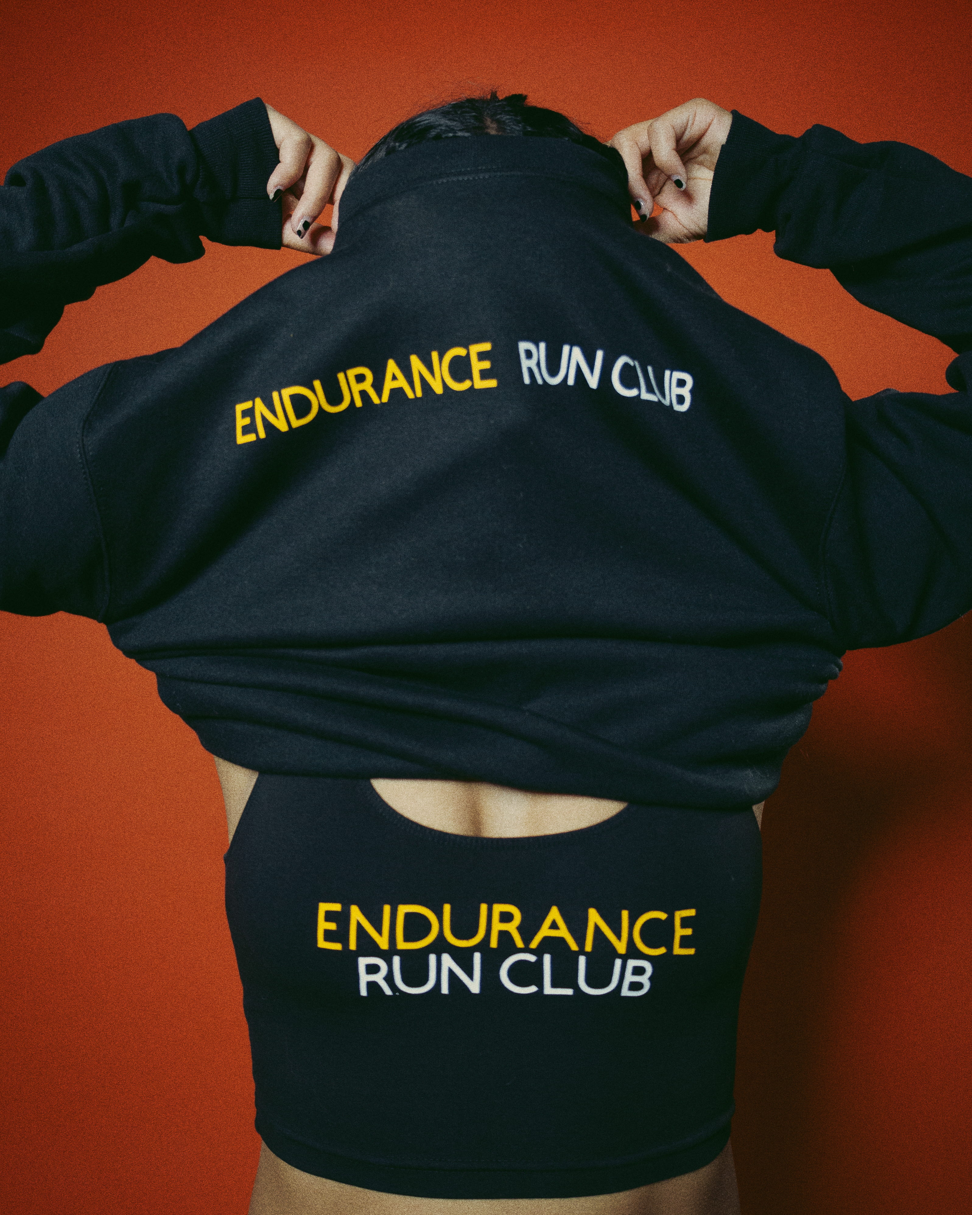 endurance run club member adjusting hoodie showing endurance run club logo on apparel