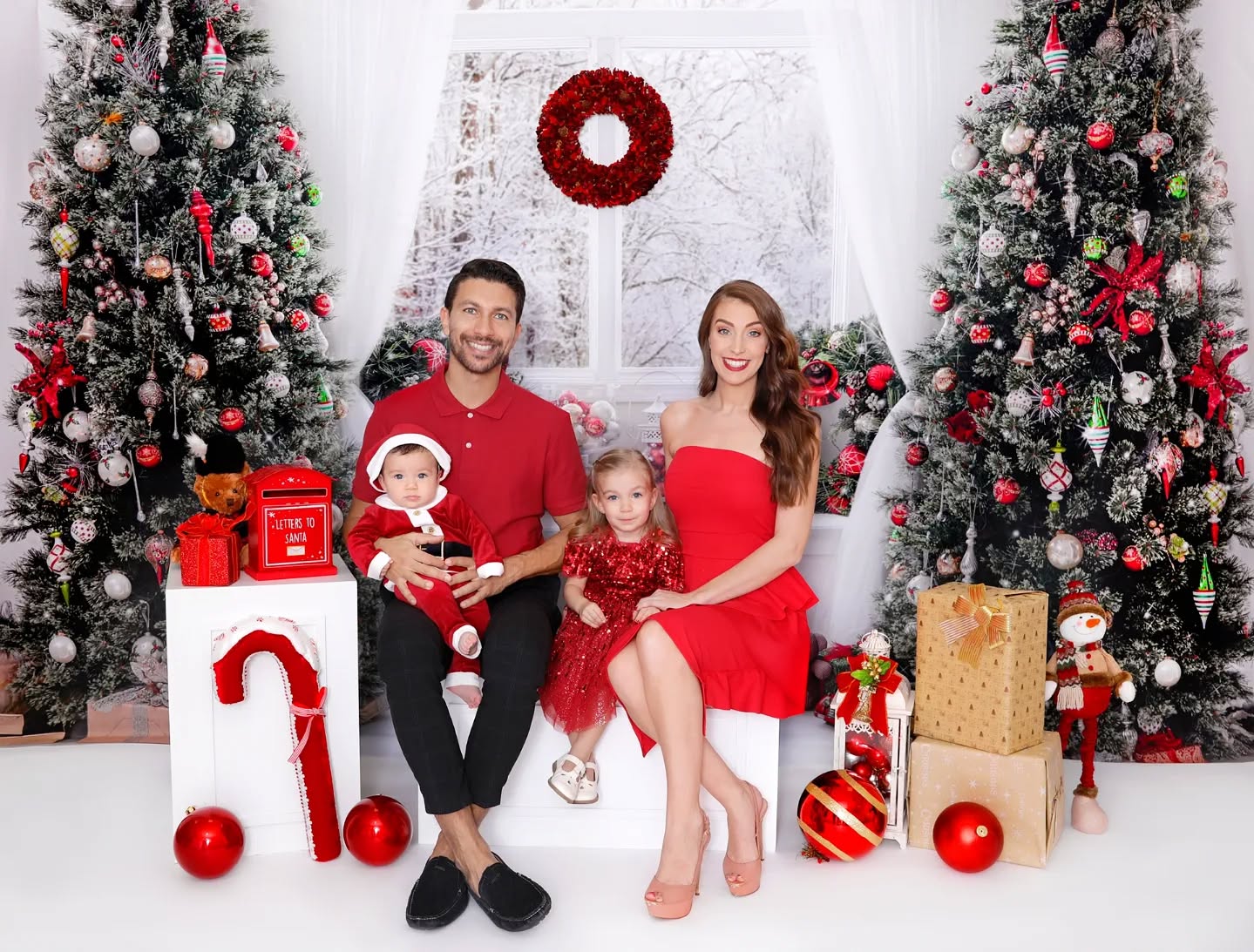 Elegant family posed in a Christmas themed setup, captured during a Christmas family photoshoot at Mahvin Photography in Dubai.