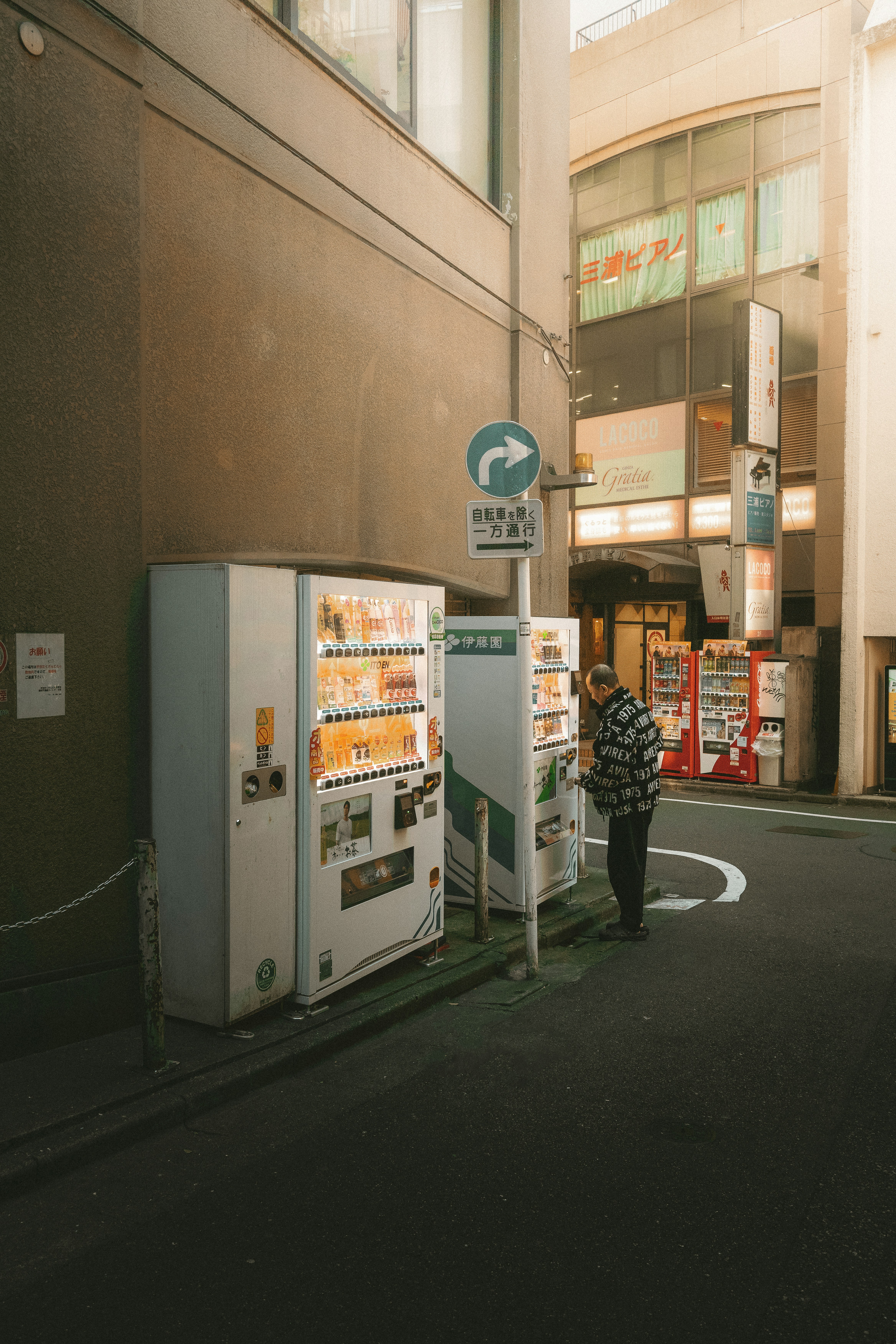 Man uses a vending machine on a city street.