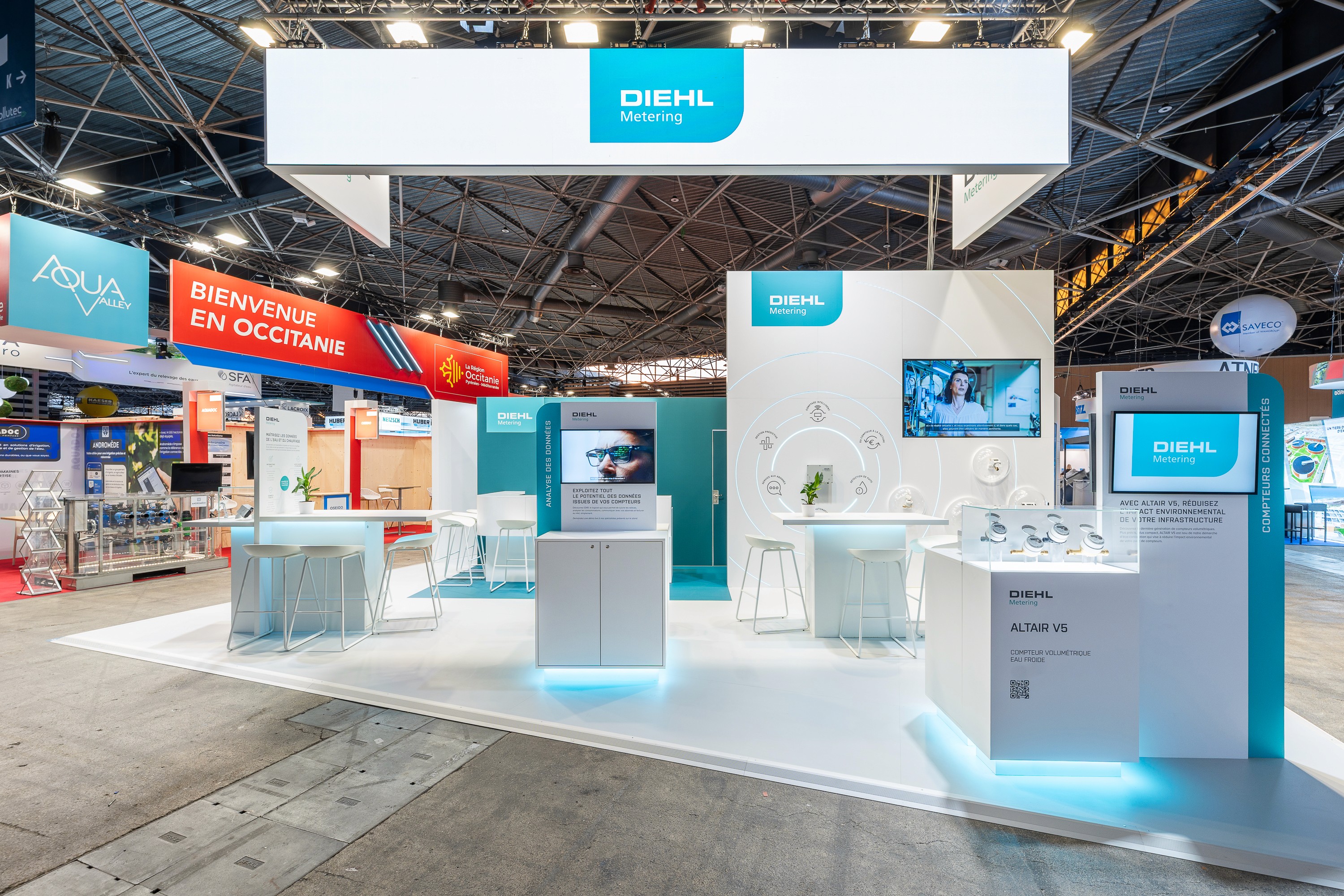 Stand Diehl Metering Pollutec 2025 réalisé par Expace – vue frontale du stand avec bandeau lumineux, espace compteurs connectés Altair V5 et mur de présentation produits interactif