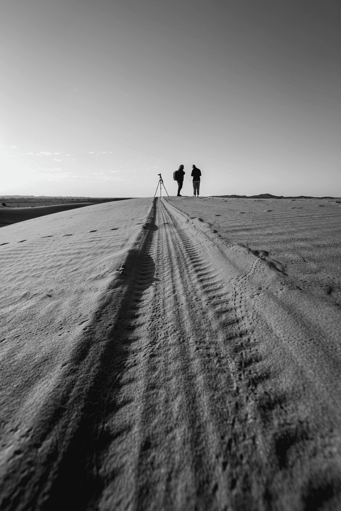 "Black and white photograph of three individuals walking towards a distant horizon on a vast, open landscape. Represents the journey of brand transformation and the tangible 'Proof in Real World' of successful narrative architecture projects delivered for US/EU B2B client