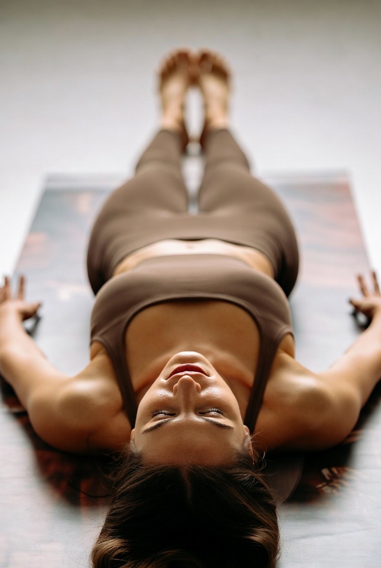Woman lying on her back on a yoga mat in a relaxation pose