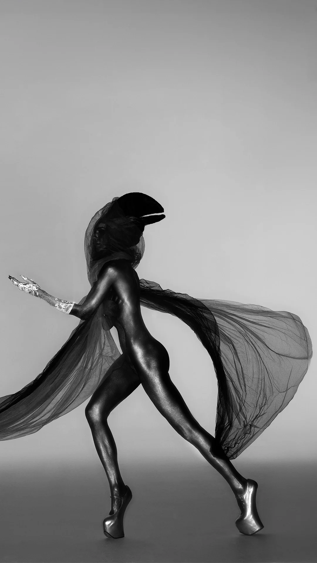 Black and white studio portrait of Daphne Guinness in full body paint, wearing the diamond-encrusted silver glove "Contra Mundum" designed by master jeweller Shaun Leane.