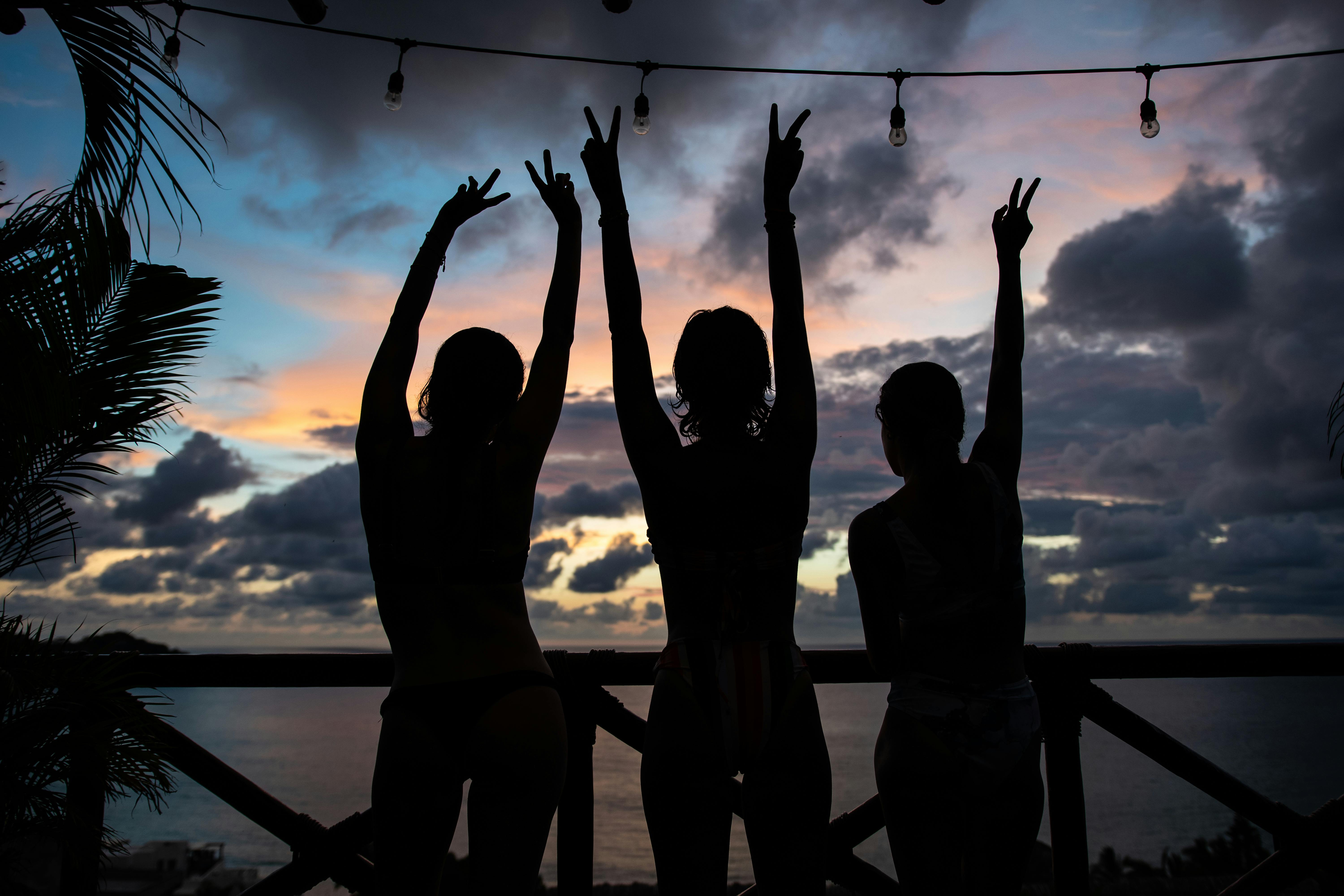 group of friends excited on an island with sunset