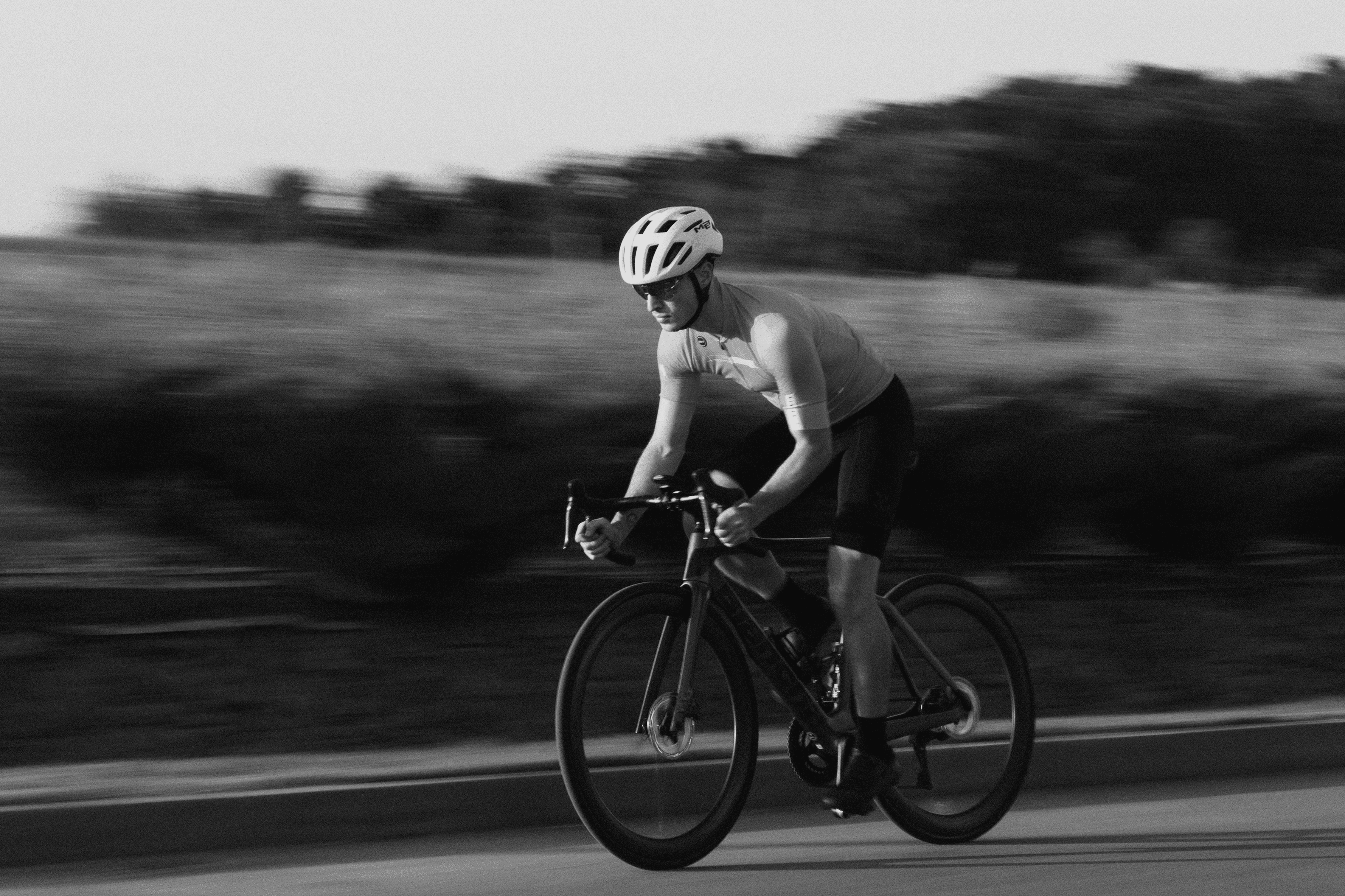 Angled view of a black athletic sneaker lying on its side, showcasing its textured, high-traction sole design against a neutral background.