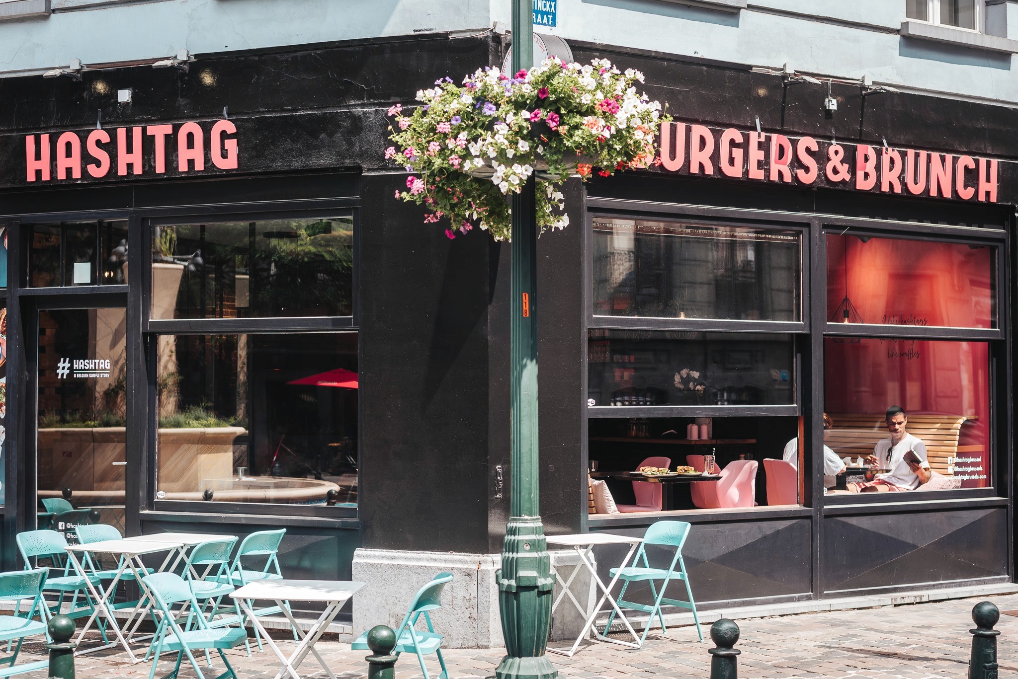 Modern home office setup with a monitor, ergonomic chair, keyboard, and indoor plants near a window with blinds.