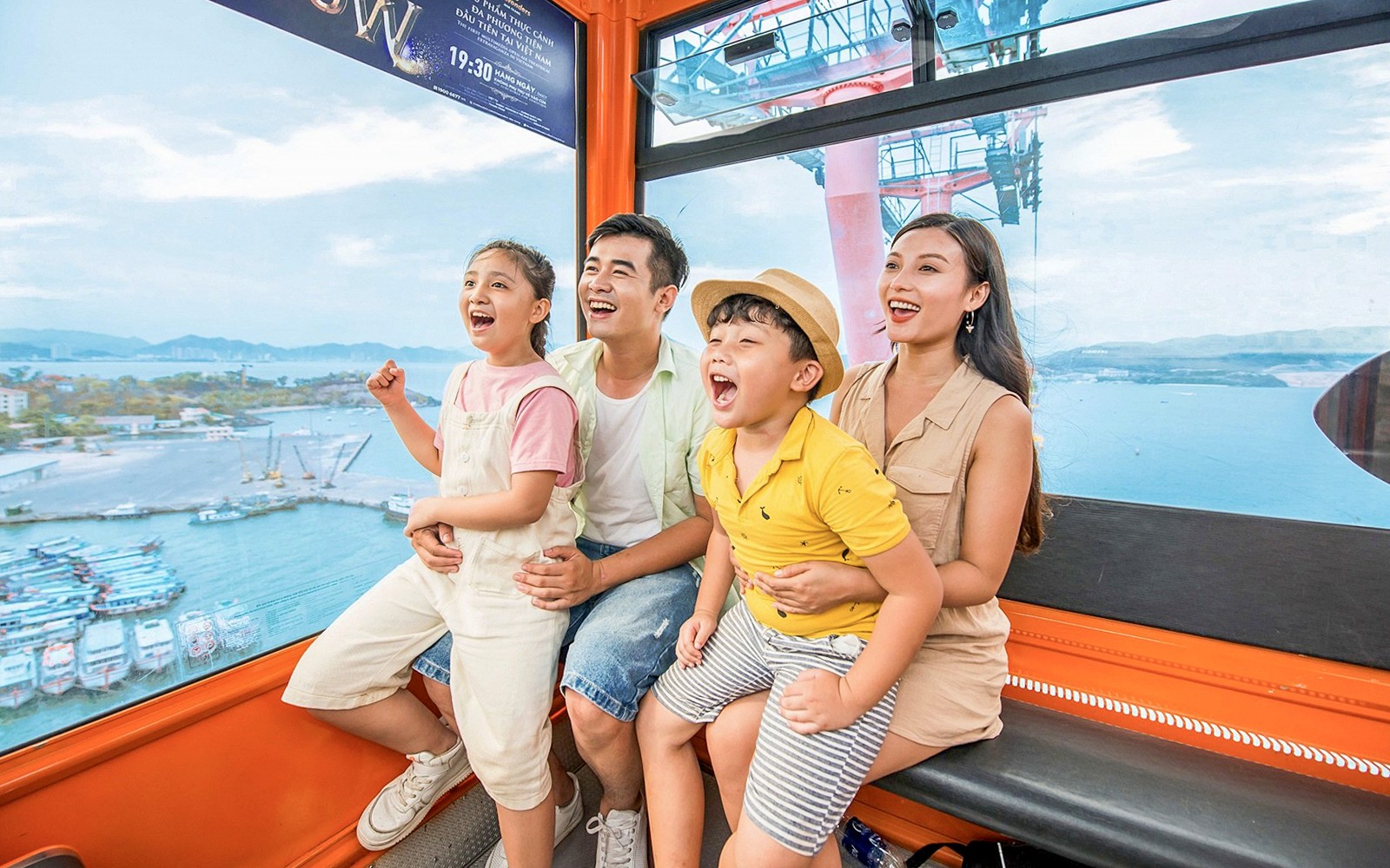 Family enjoying a cable car ride at Vinwonders, Nha Trang, Vietnam with ocean view.