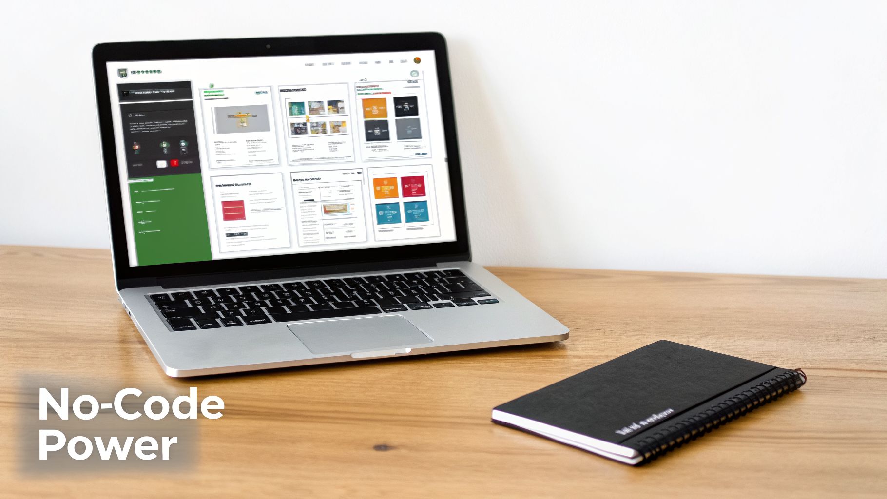 A laptop displaying a no-code development interface and a notebook on a wooden desk.