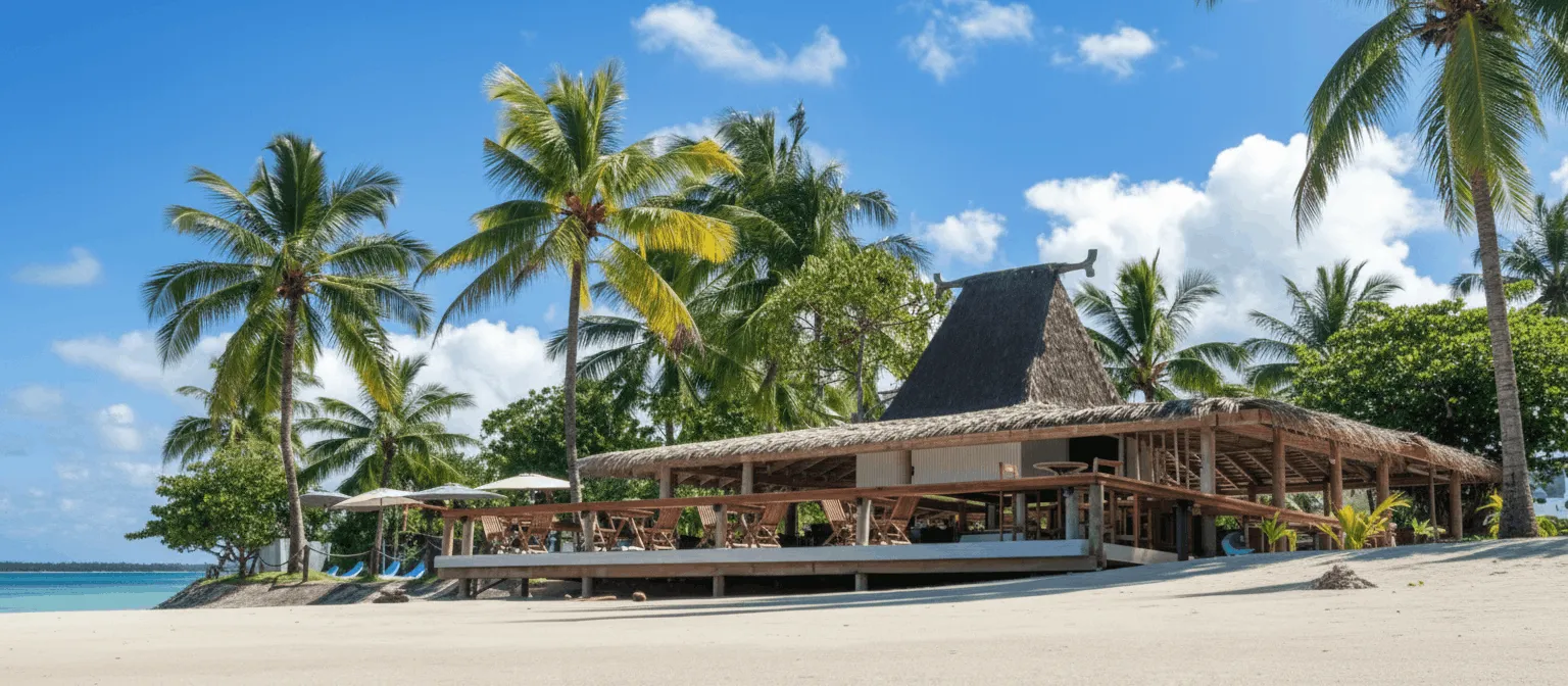Beachfront bar on a blue sky day with scattered clouds and palm trees at the Uprising Resort Fiji