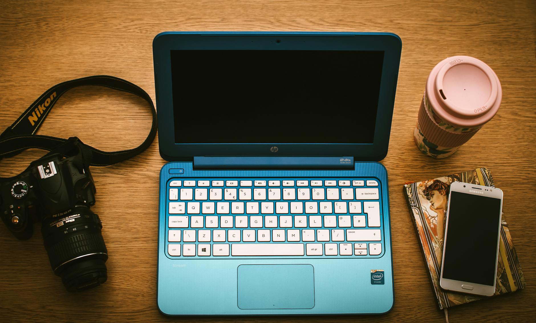 A prospective student reviews a digital brochure for a teacher preparation program on a laptop at a cafe.