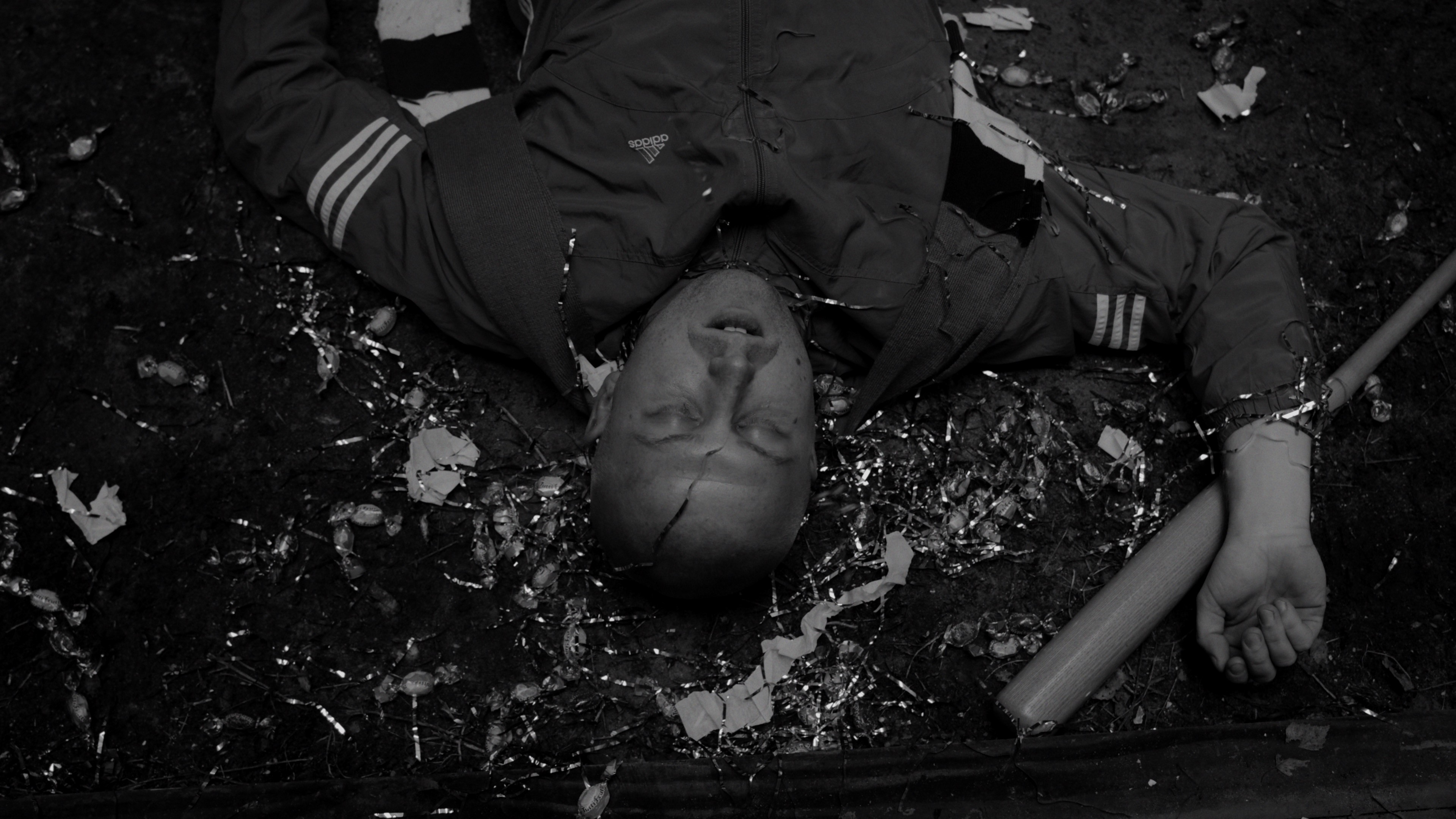 Overhead shot of a man lying defeated on the ground surrounded by debris.