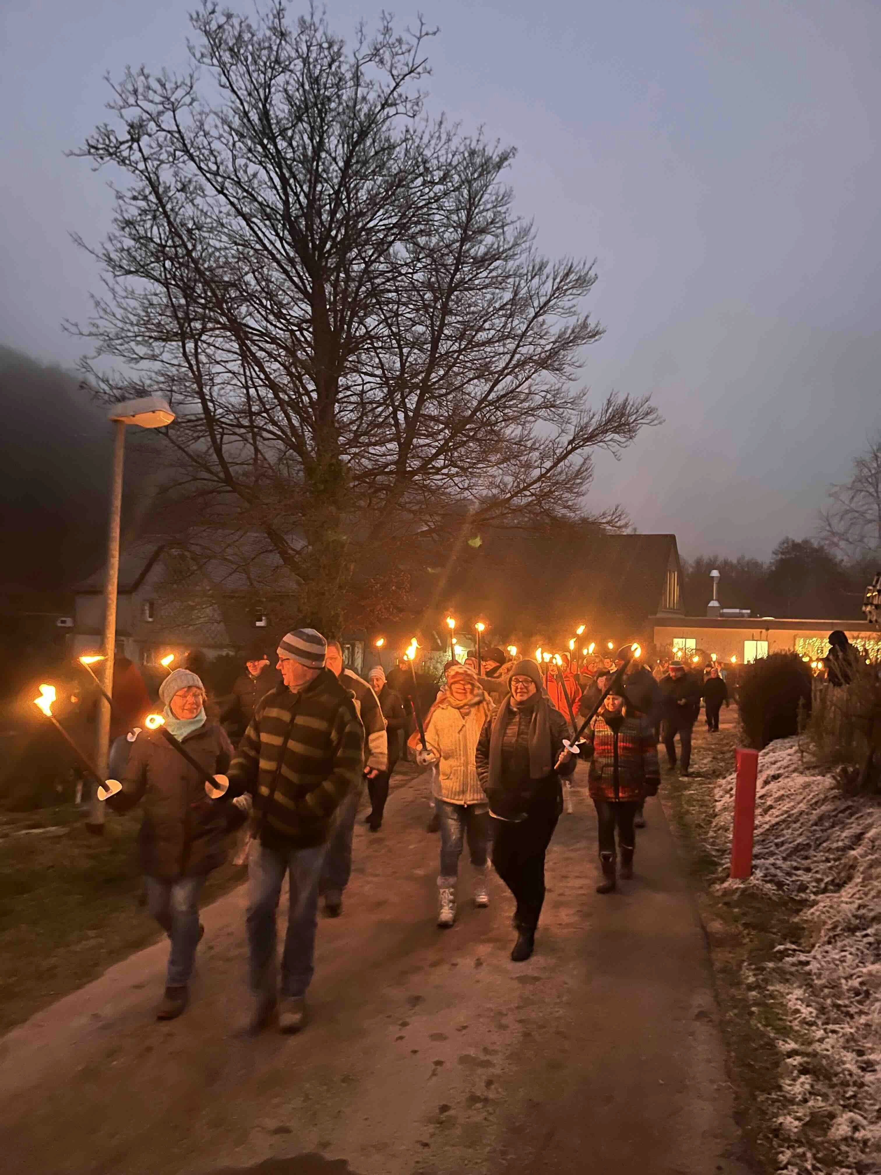 Gruppe mit Pechfackeln laufen übern Campingplatz