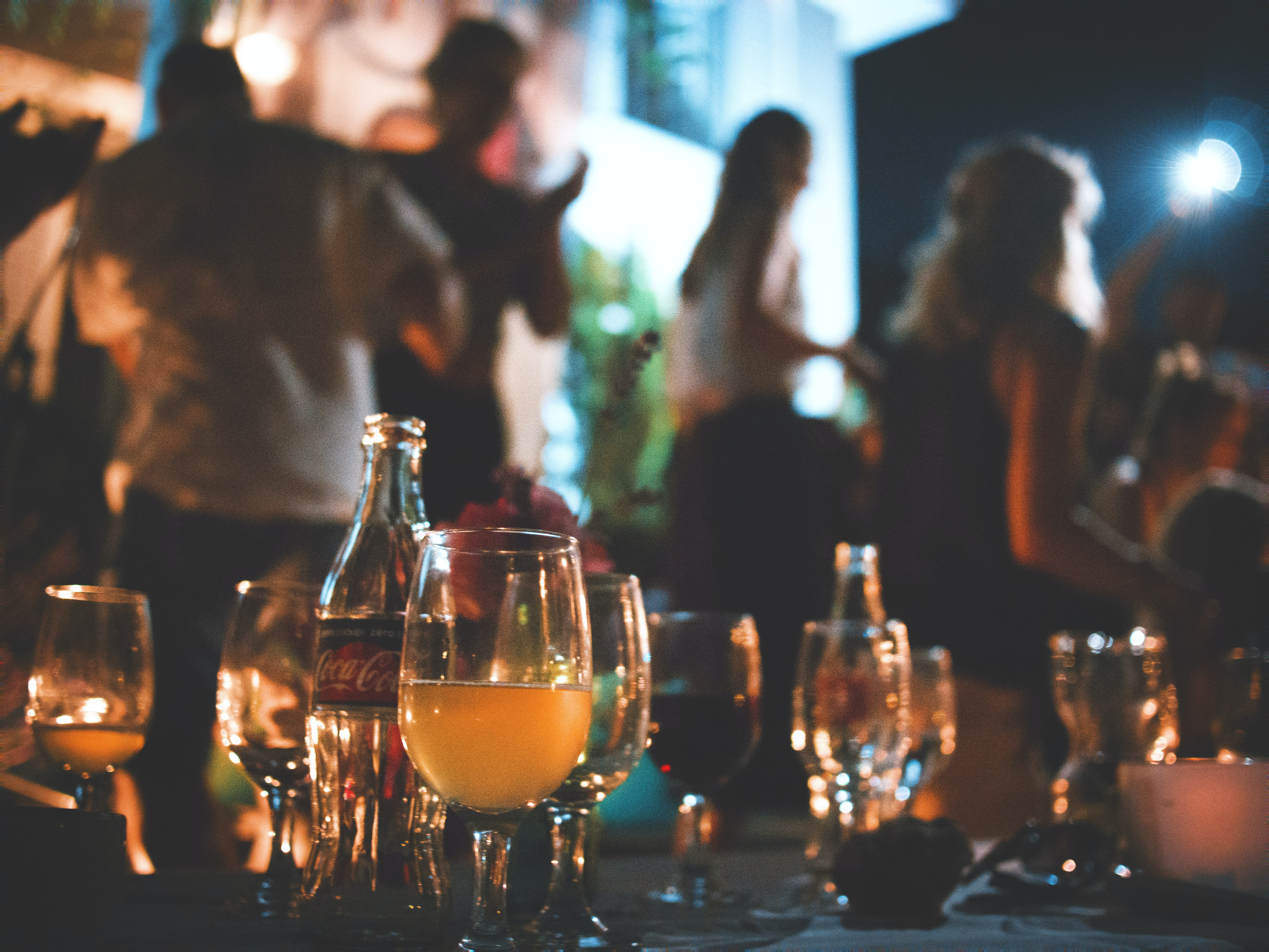 An evening event showing people at a party of a table of drinks