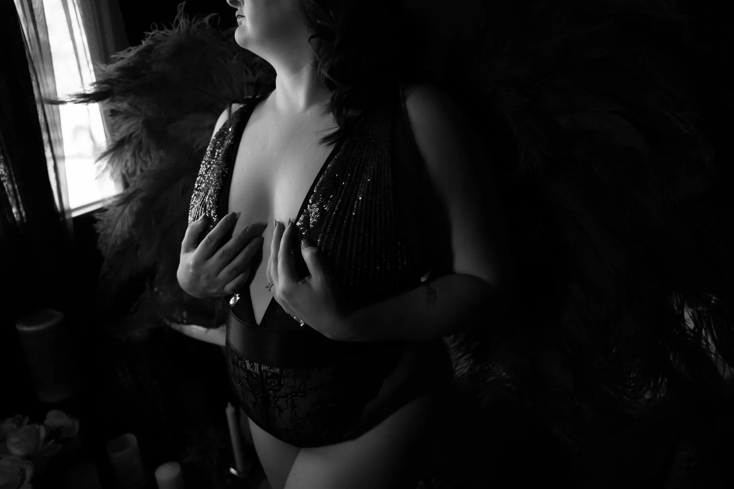 Black-and-white portrait of a client in a feather wrap