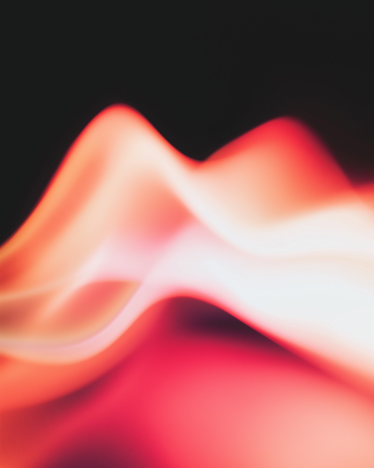 Flowing abstract wave of red, coral and white light