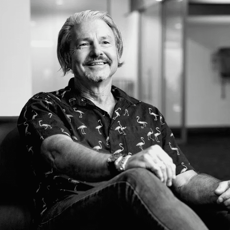 Portrait of a person in a pink sweater against a light background