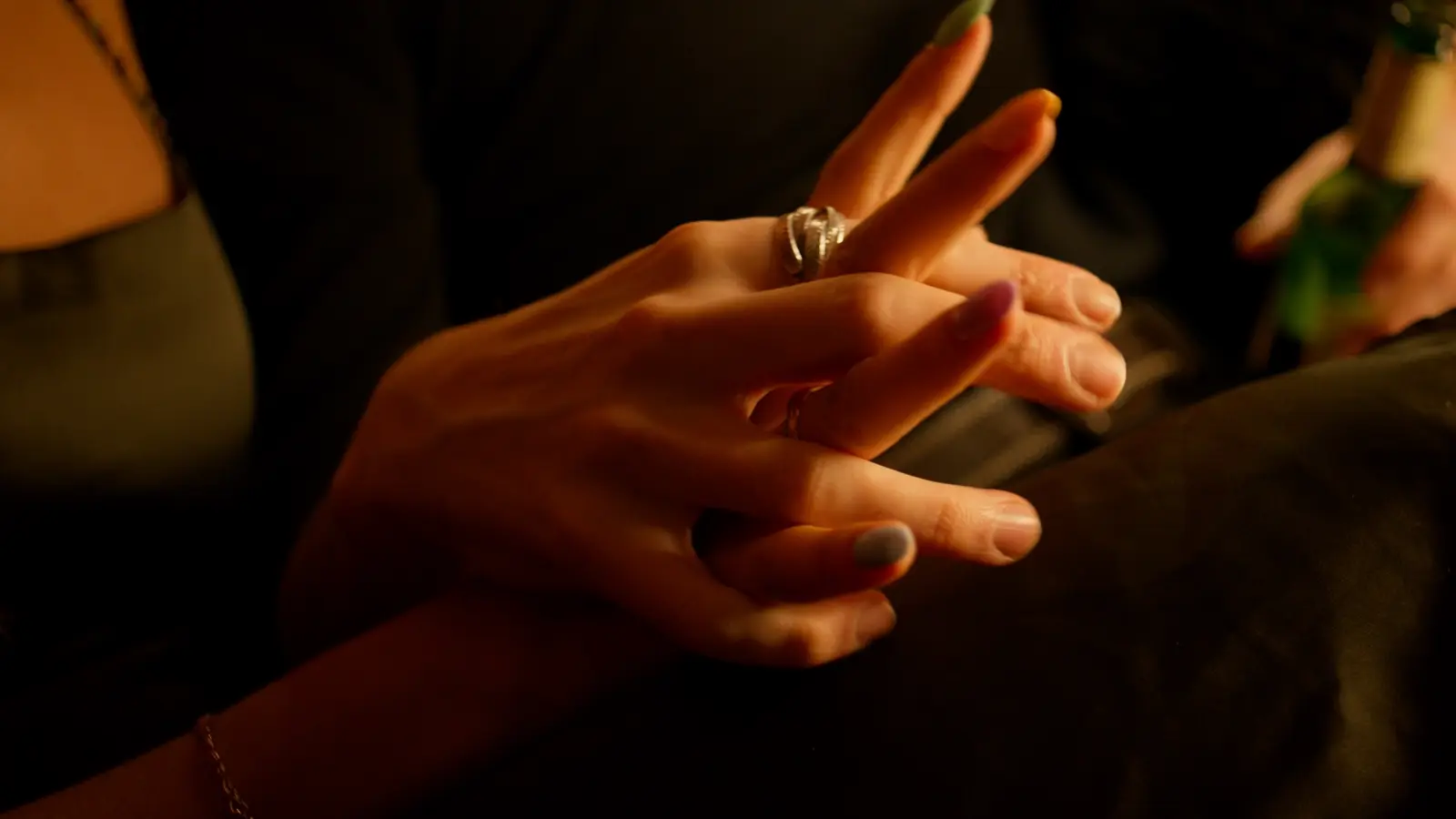 Close-up of two people's hands touching at a table
