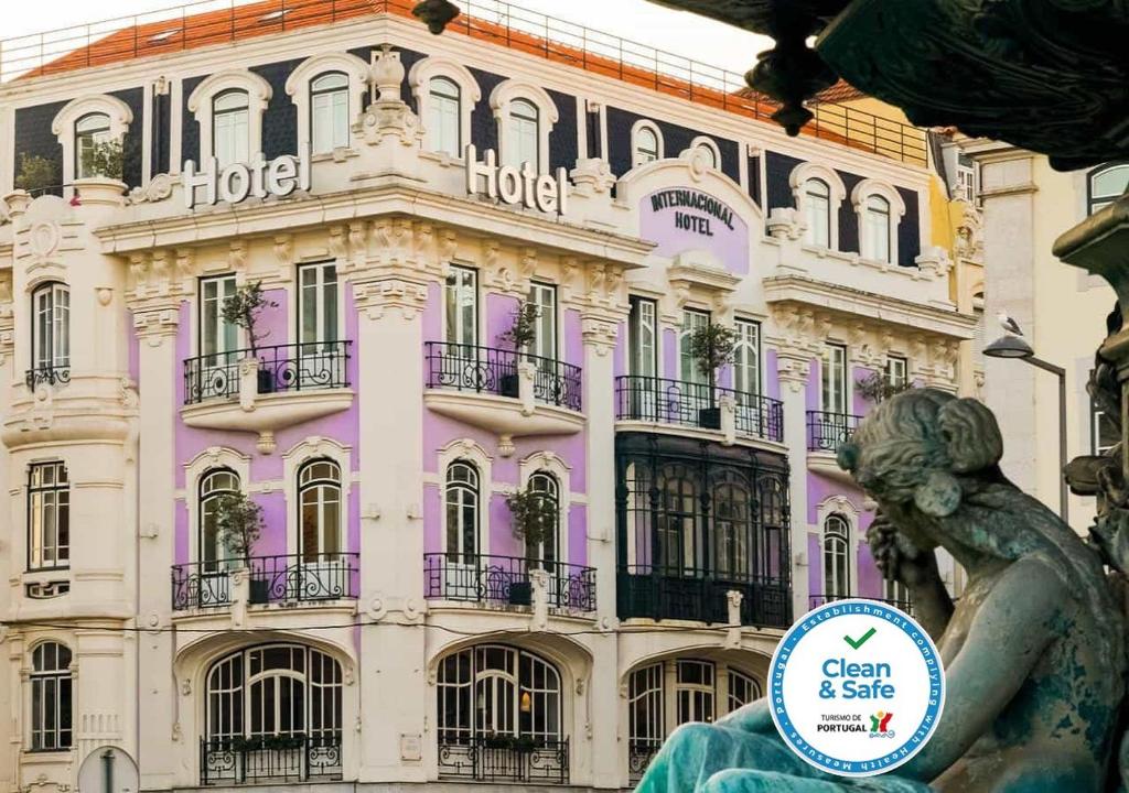 Internacional Design Hotel: ornate corner hotel façade beside a bronze statue