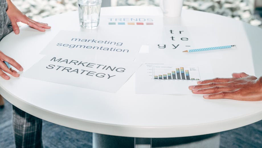 Two professionals collaborate on marketing strategy and segmentation at a round table.