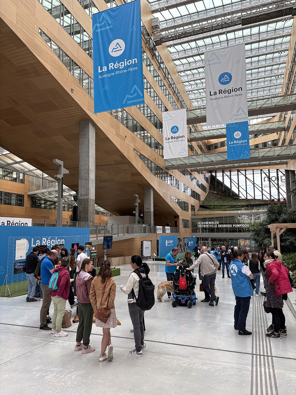 Vue intérieure d’un conteneur d’exposition présentant les portraits en noir et blanc de Frédéric Bourcier, éclairés par des néons au plafond.