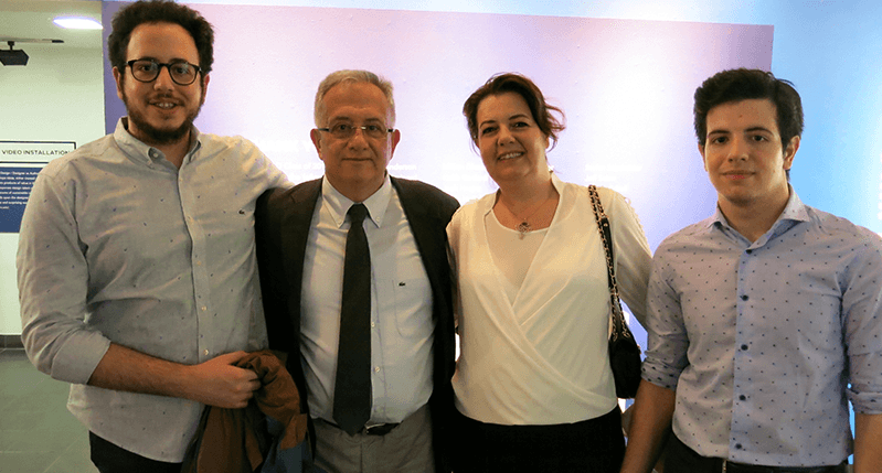 A group of people standing in an exhibition room.