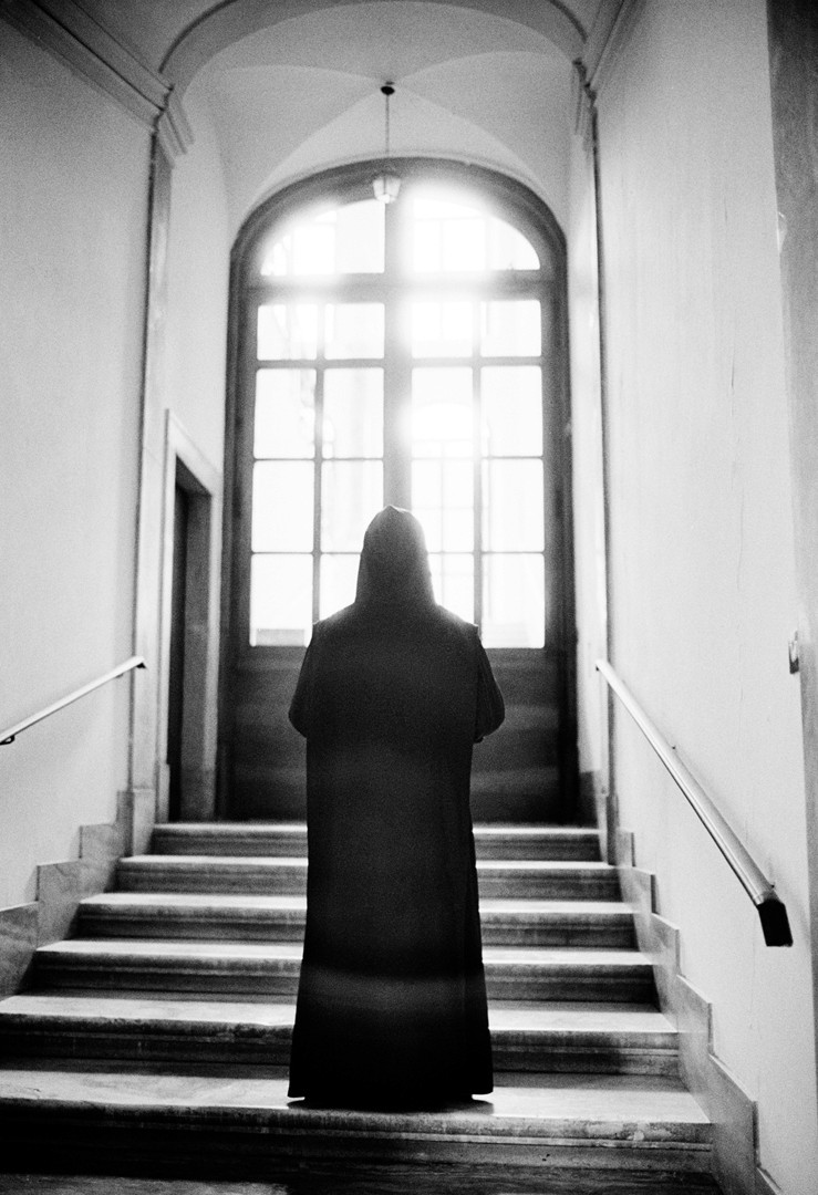 Argen – Loud Silence – portrait in a suit with bandaged face and intense downward gaze