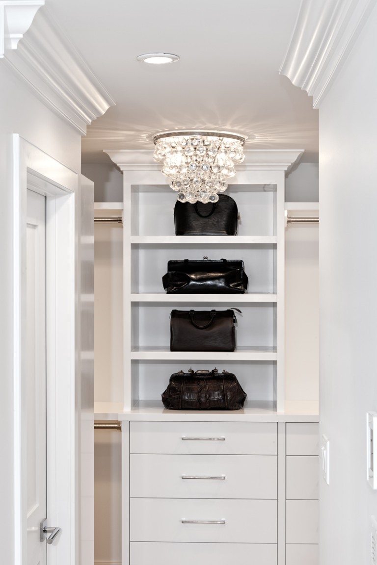 Image of Luxury closet interior design with built-in shelving, drawers, and high-end handbags by KHD Homes.