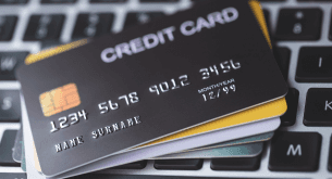A stack of credit cards on top of a keyboard.