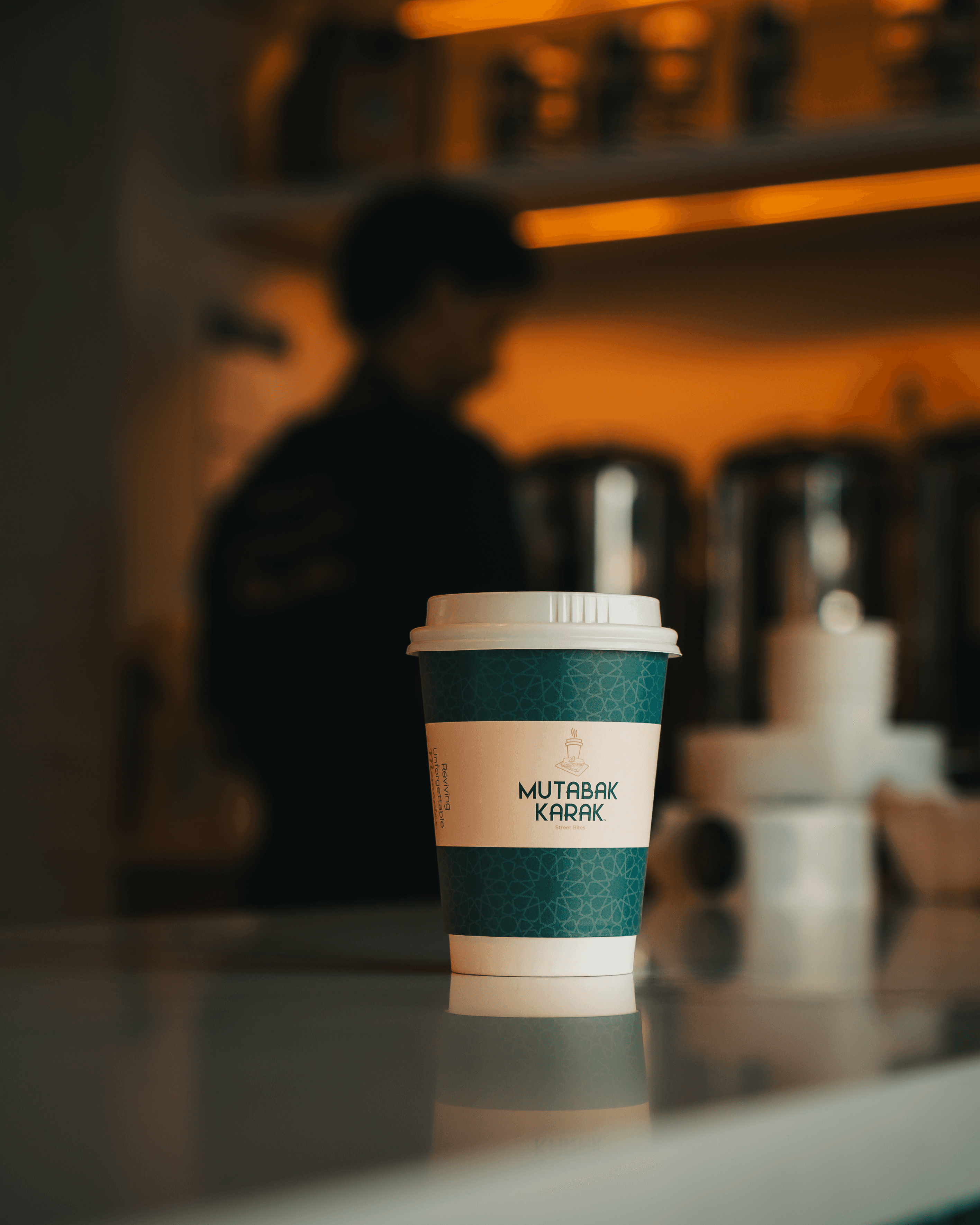 Milk being poured into black coffee in white cup