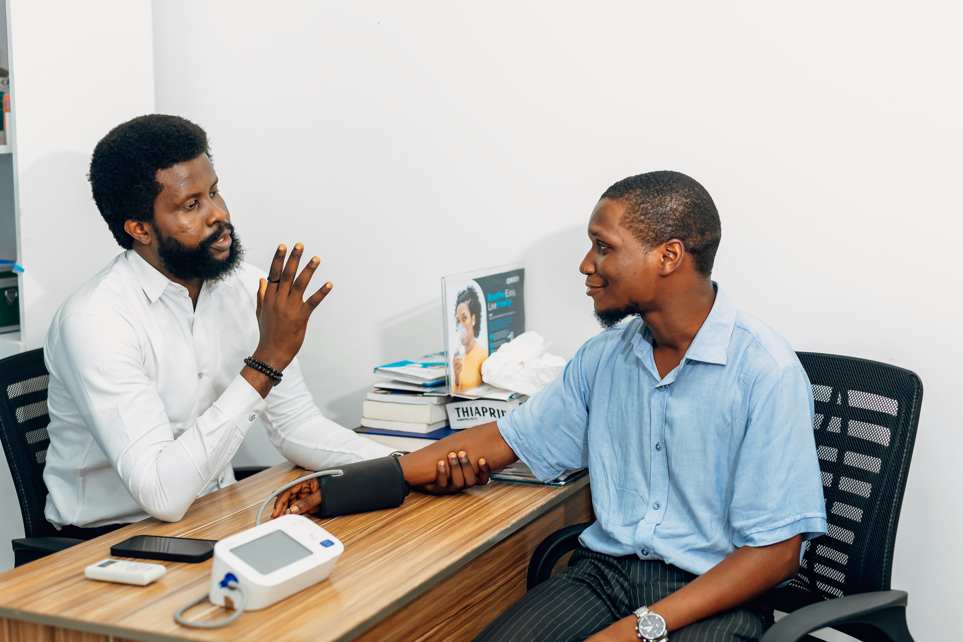 Two men sitting at a desk talking to each other