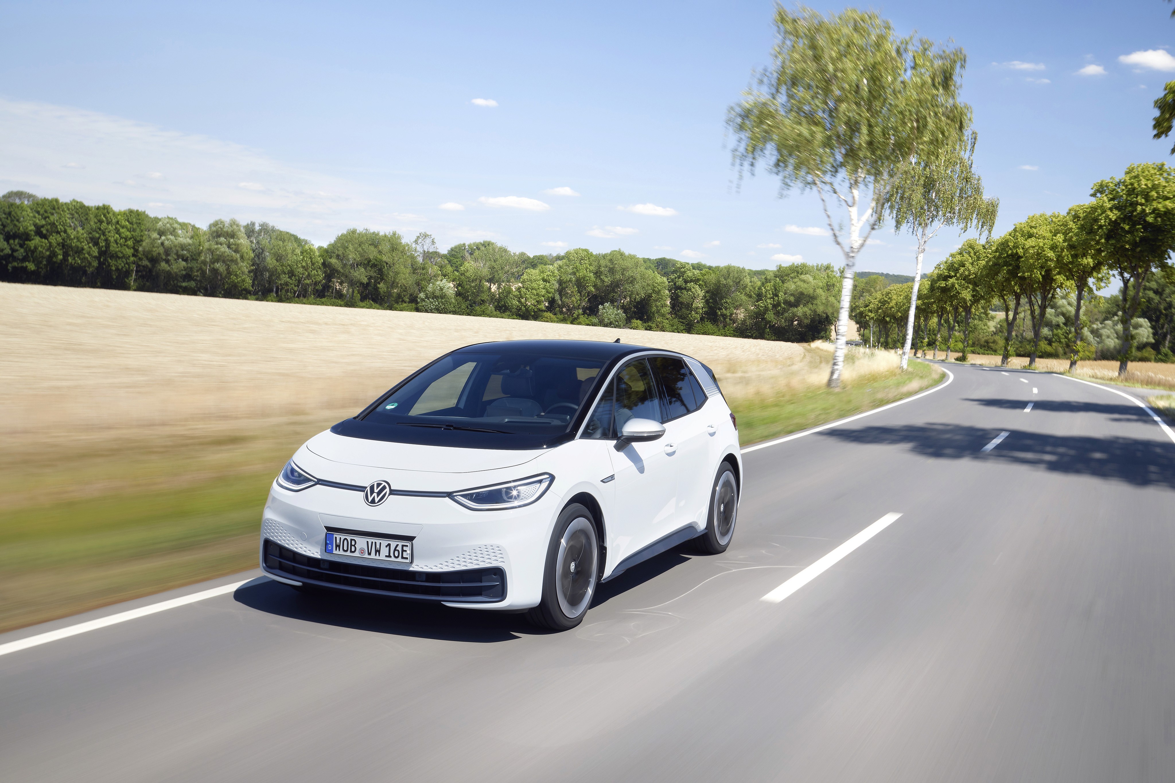 Volkswagen ID.3 blanche sur route sinueuse, compacte électrique en conduite dans un paysage rural