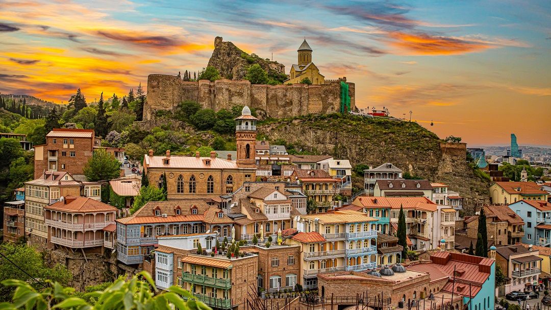 Winding road through mountain range at sunset.