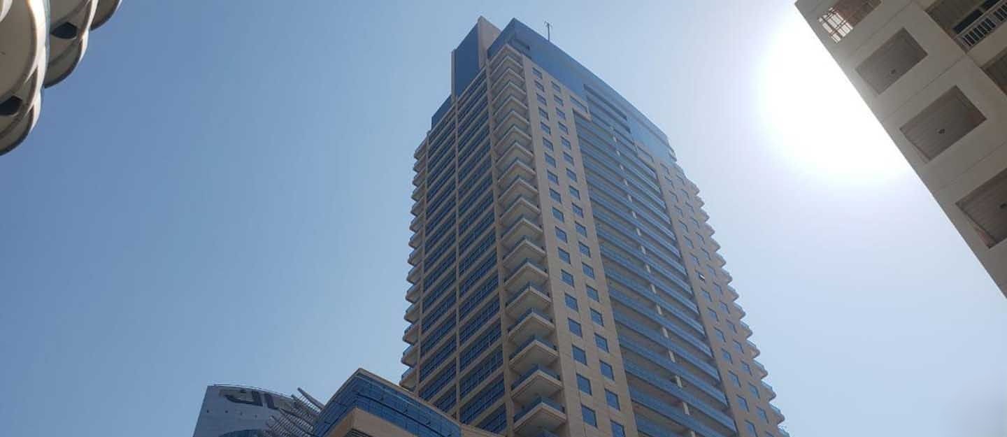 Looking up at the impressive facade of a luxury residential tower in the heart of Dubai Marina.
