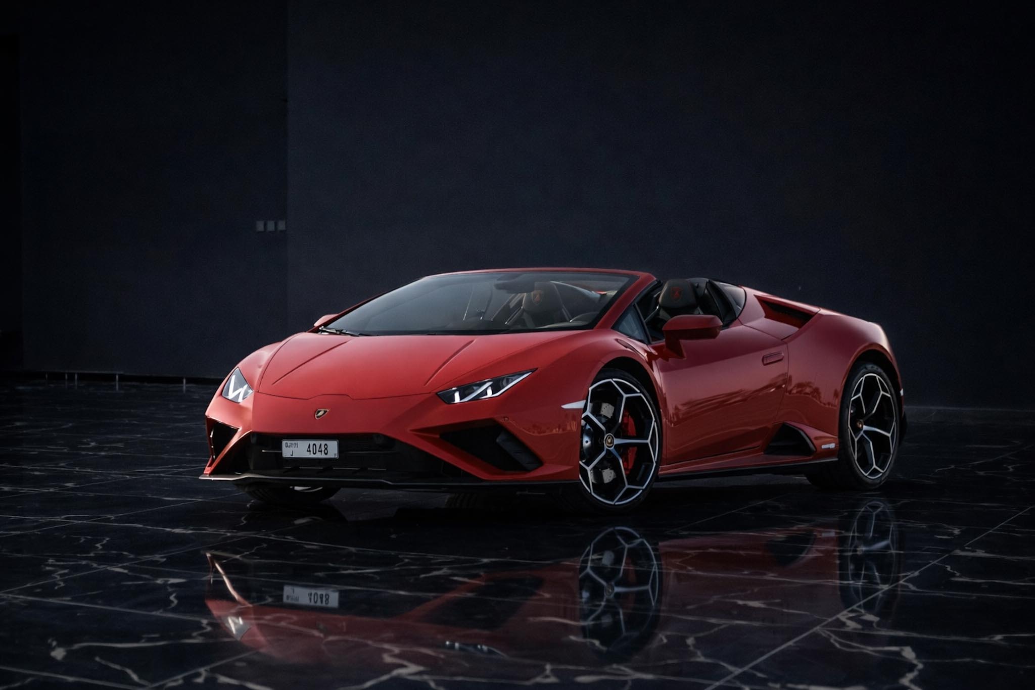 Red Lamborghini Huracán EVO Spyder parked in Dubai, available for luxury supercar rental