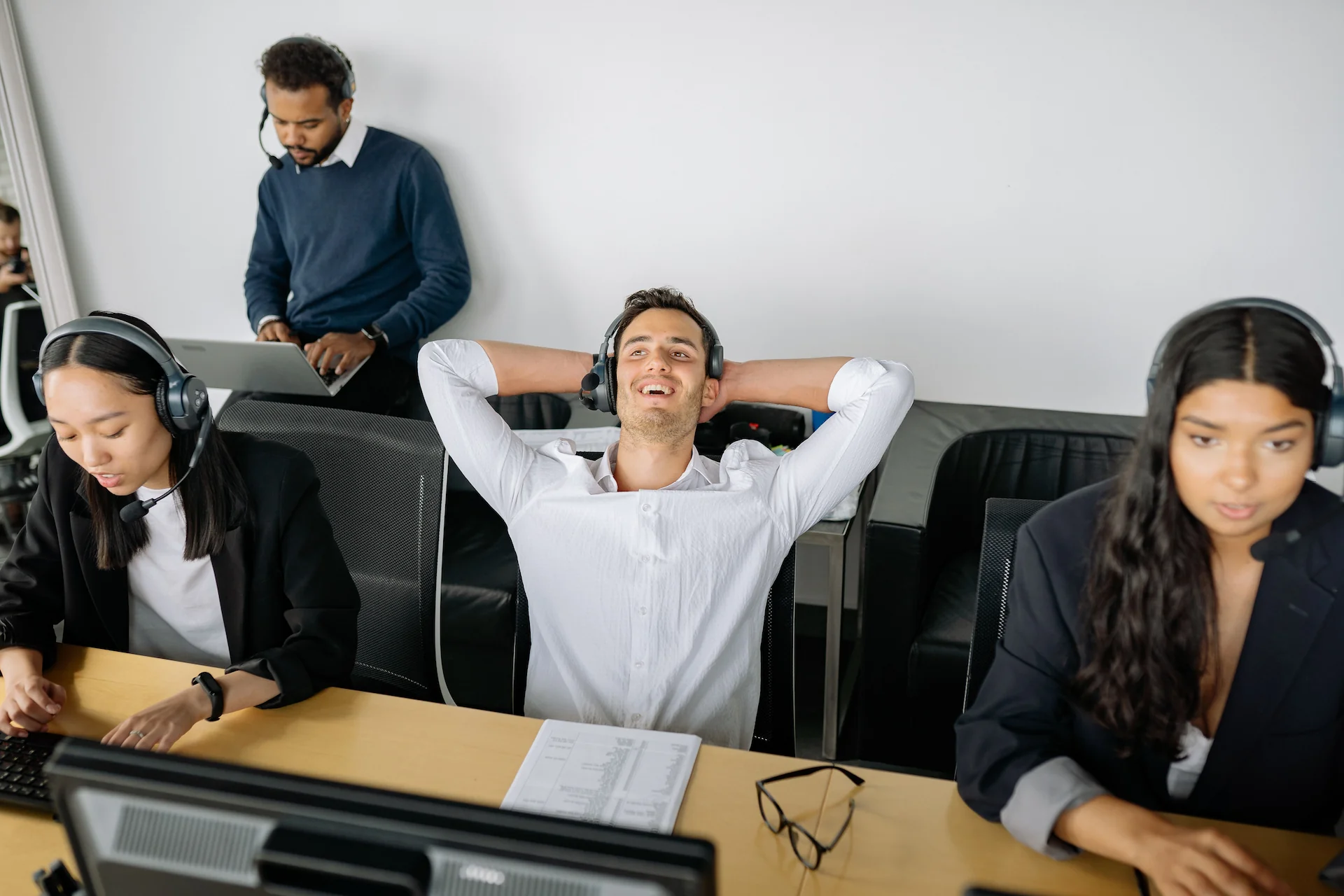 Vertriebsteam mit Headsets bei der Kaltakquise im Büro