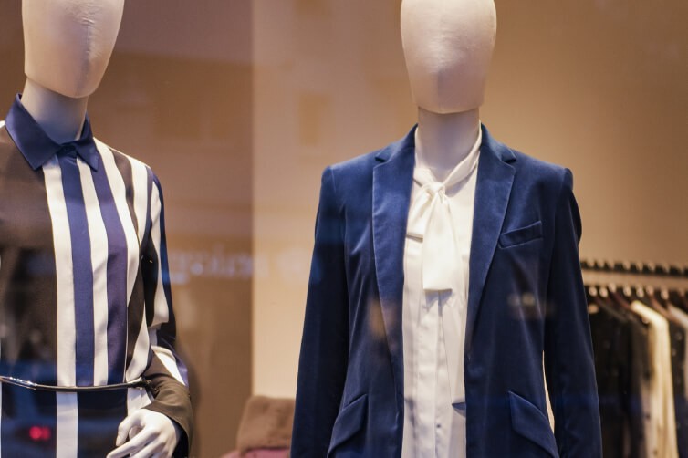 Store mannequins dressed in striped dress and blue blazer outfit