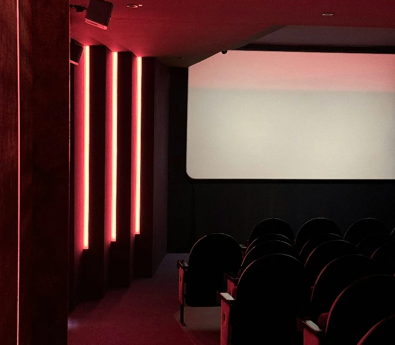 a room filled with red chairs and a table