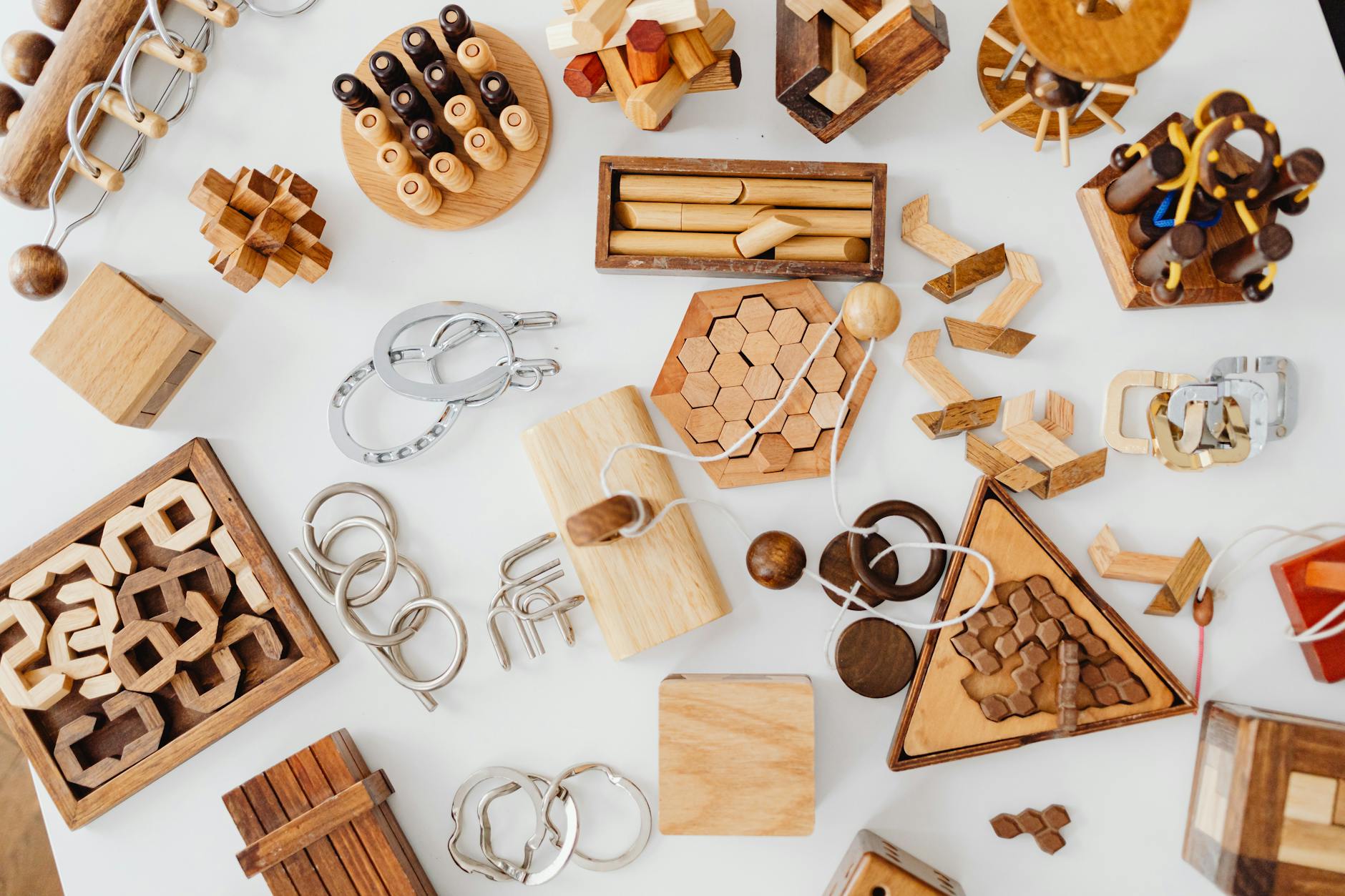 Close-up of two childrens hands moving wooden blocks and gears to solve a complex logic board game.