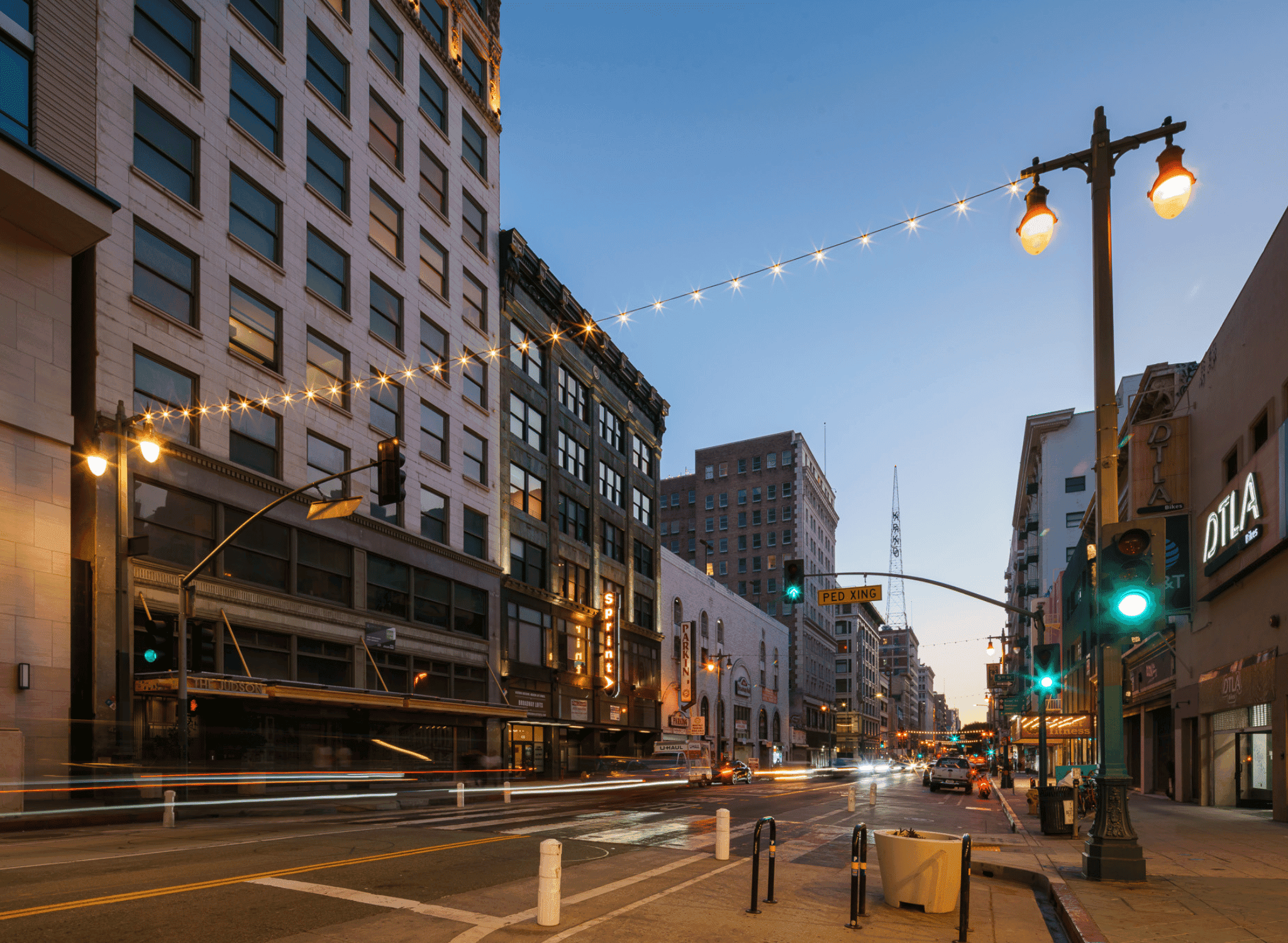 Evening streetscape featuring The Judson along Broadway in Downtown Los Angeles.