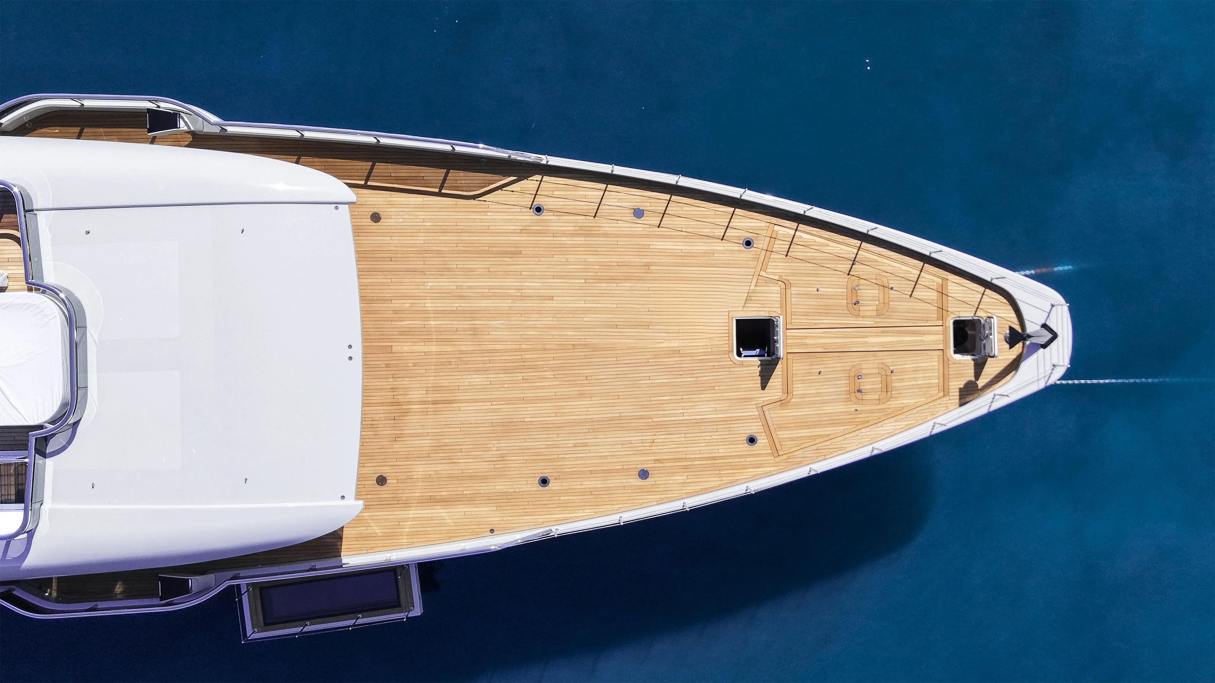 Top-down aerial view of a luxury yacht teak bow in turquoise waters for yacht registration in Turkey