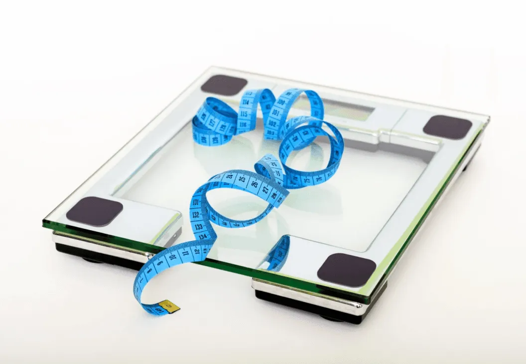 bathroom scale and measuring tape representing weight loss helping improve men’s health
