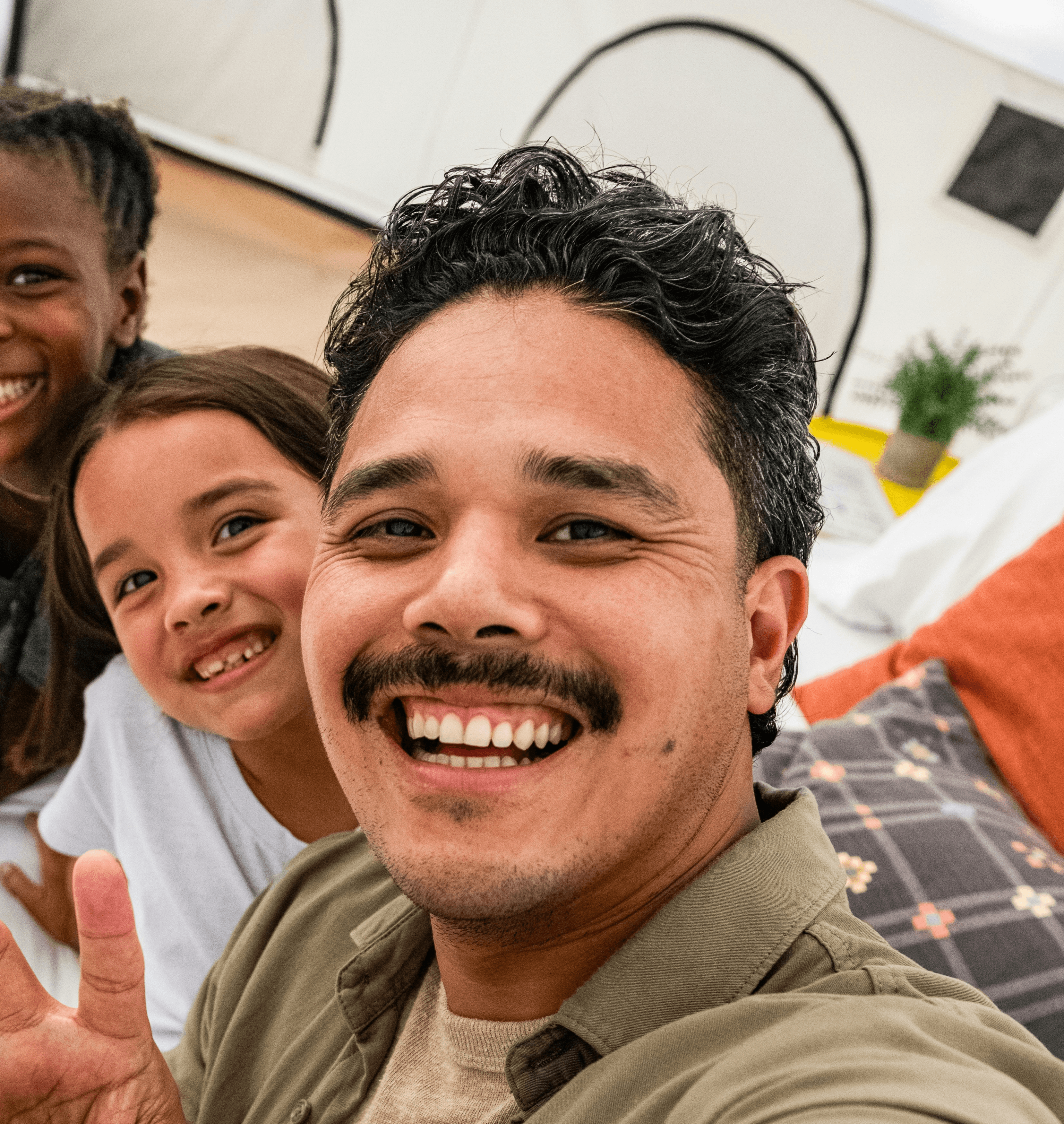Man and two girls taking a selfie in a tent