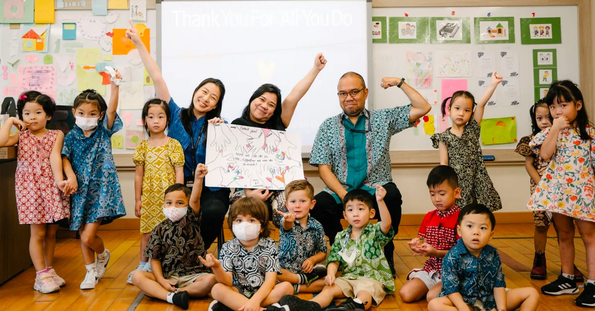 person writing on brown wooden table near white ceramic mug