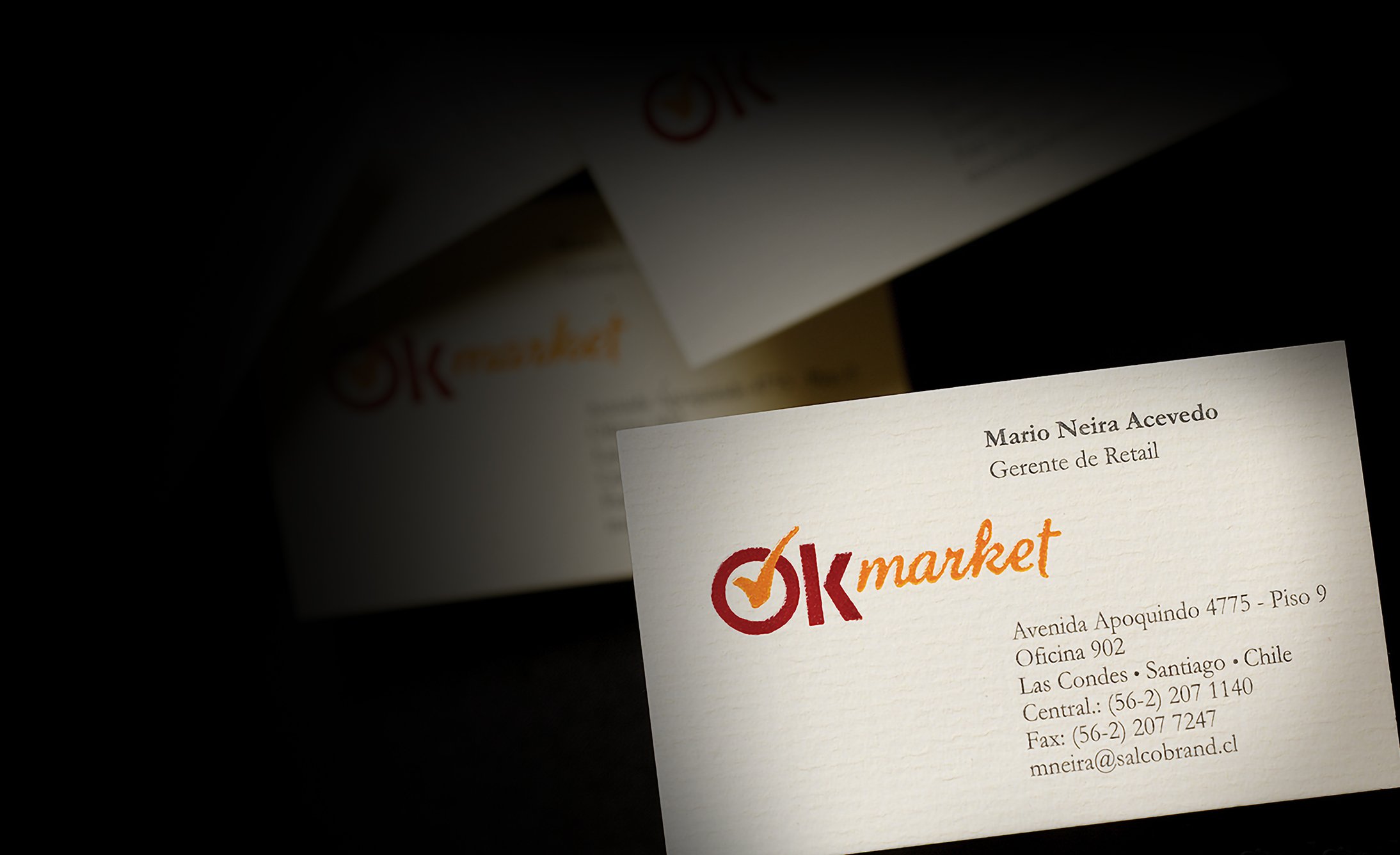 A business card for "OK market" with a logo featuring a check mark. It lists contact details, including a name and position. The card has a professional tone.