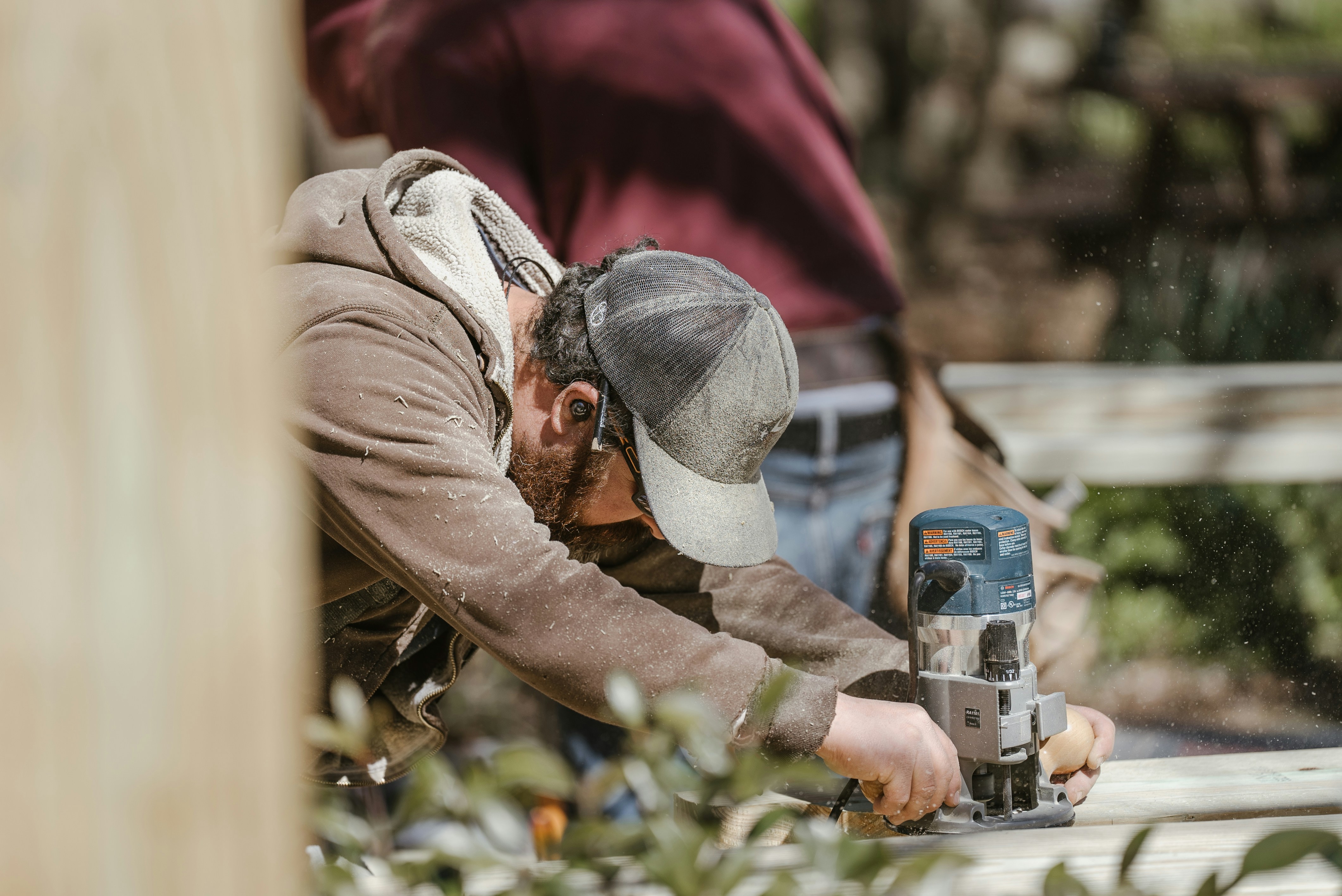 Trabajador con protección auditiva utilizando maquinaria en un entorno laboral ruidoso